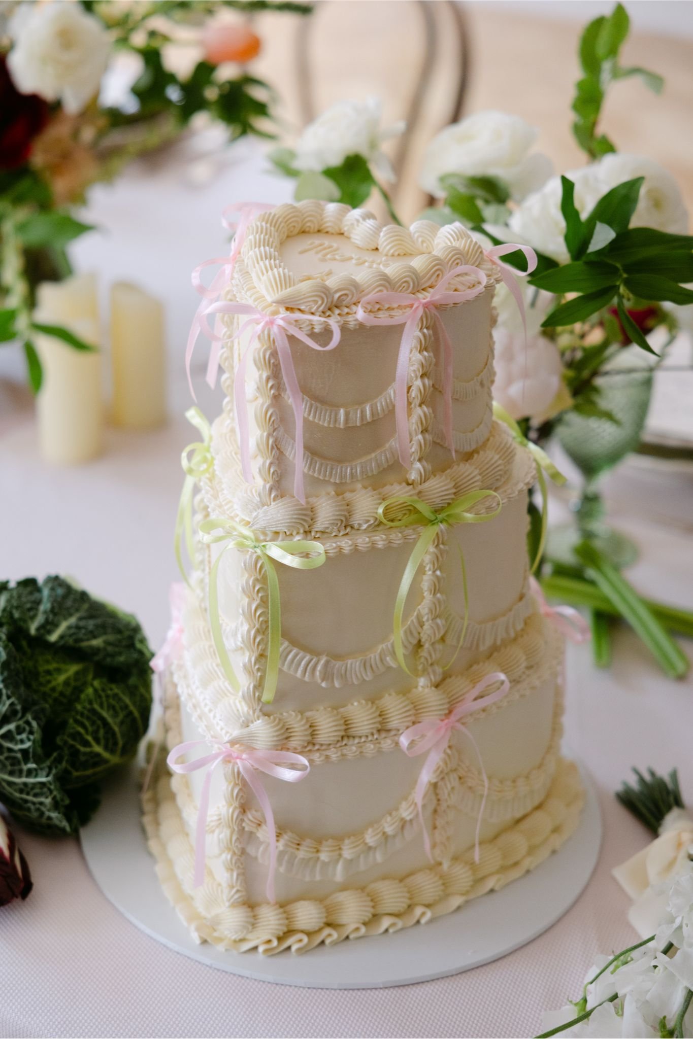 Elegant retro-inspired wedding cake by The Cake Hun featuring tiered vintage piping, soft ivory buttercream and delicate pastel ribbon detailing. A modern, design-led wedding cake blending nostalgic styling with contemporary aesthetics, perfect for c