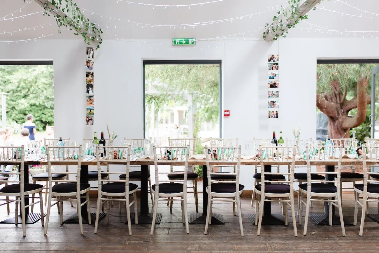 A long wedding reception table styled with natural details, greenery and relaxed seating, creating a sustainable, modern celebration planned by Wild Soul Weddings, eco wedding planners in the UK. Marie Francesca Photography.