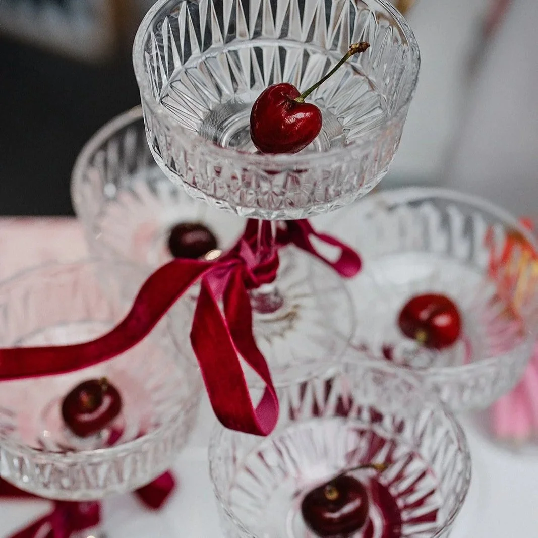 Glasses with cherries in and some matching ribbon.