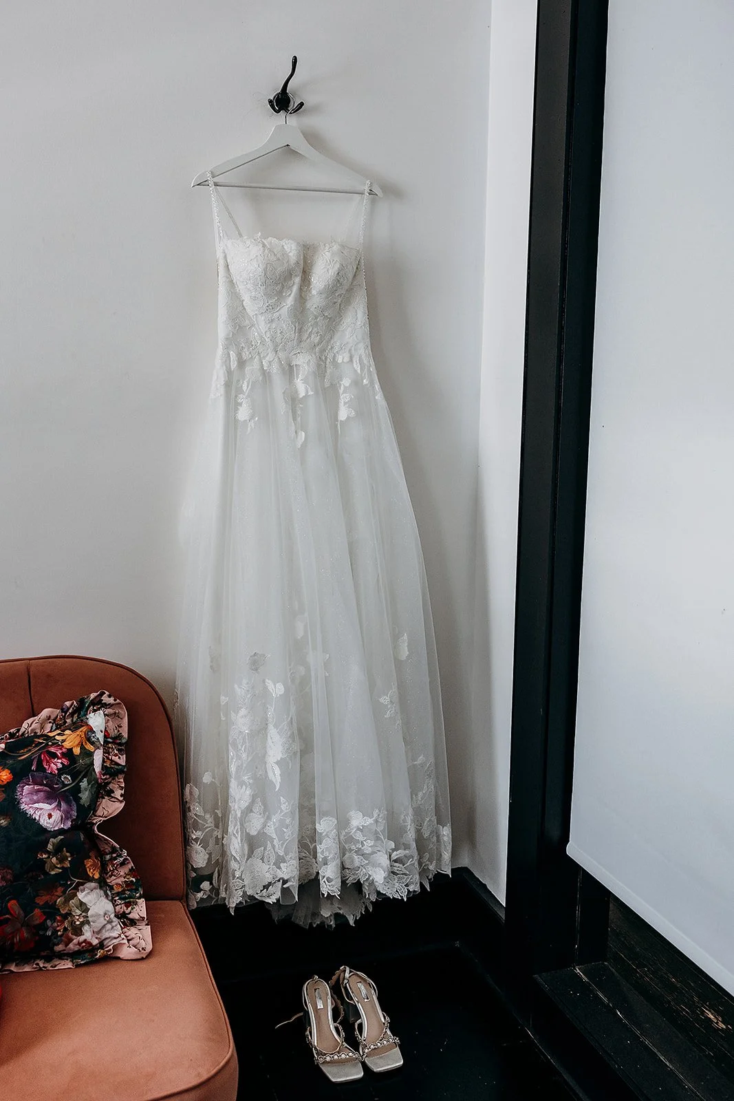 Marie's white wedding dress by Aimee Bridal Couture hanging above her Wedding shoes.