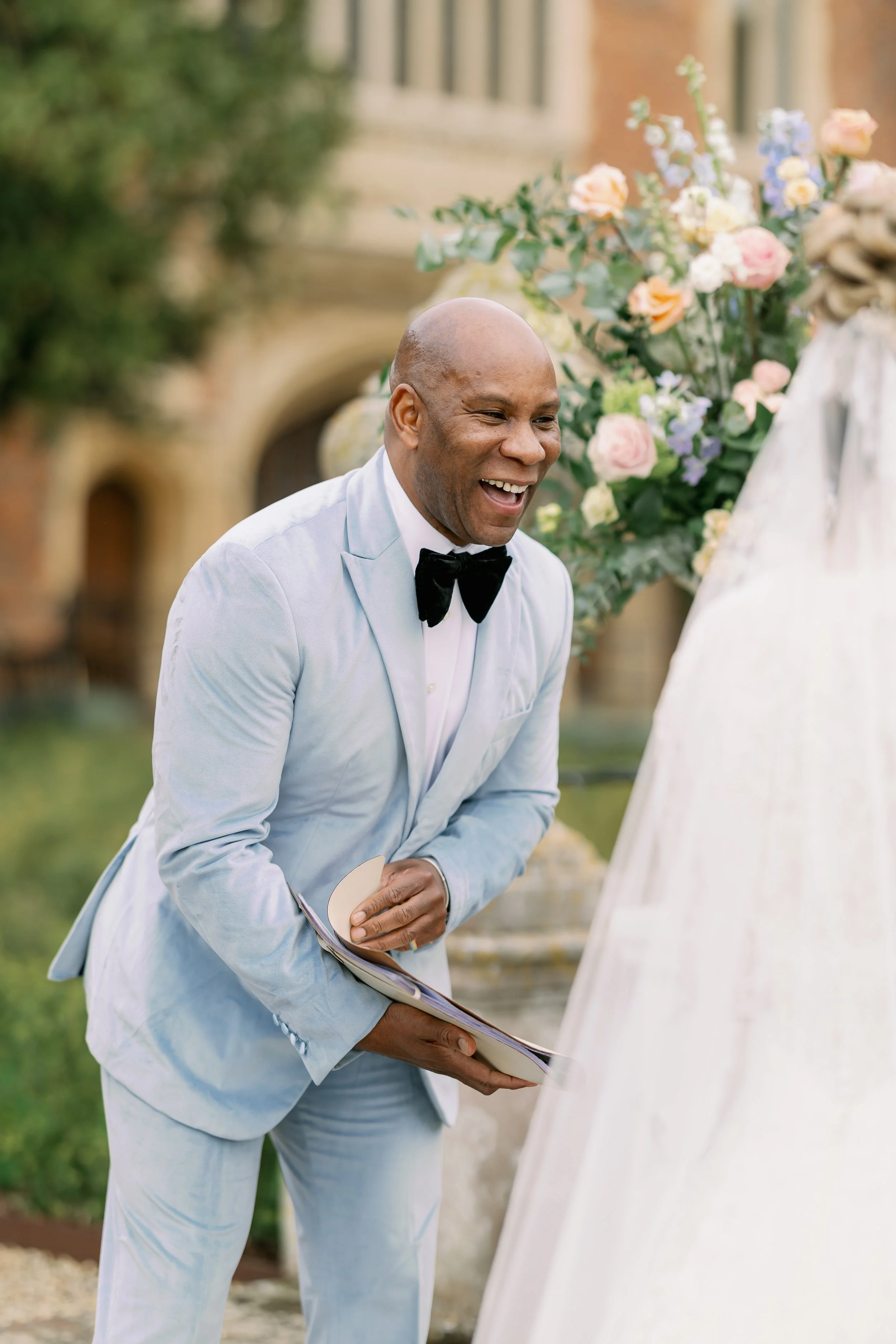 Dave Octave Celebrant in a light blue blazer, sharing a funny moment during a ceremony.