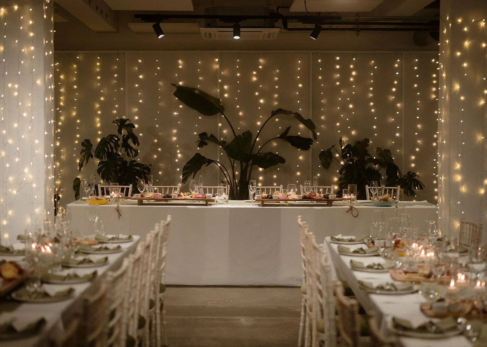 Tables set with atmospheric fairy lights, ready for wedding dinner.