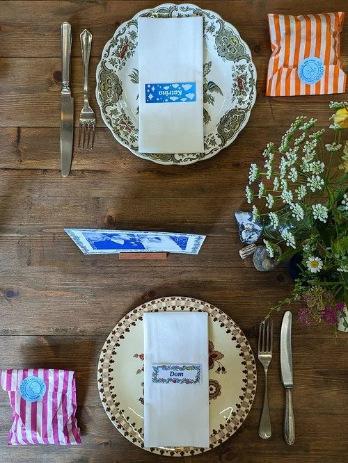 Rustic wedding table setting featuring personalised stationery by Different Day Design Studio, Dorset. With vintage crockery, striped favour bags, and bespoke name cards, this charming design adds a creative, handcrafted touch - perfect for relaxed c