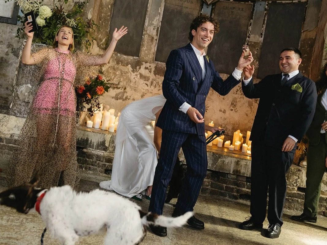 A funny moment at a wedding conducted by Tab Taylor from Say it Right Ceremonies. Tab throws her arms in the air as a small white dog makes an appearance at the alter. The groom holds a ring and smiles, whilst the bride is crouched down behind him.