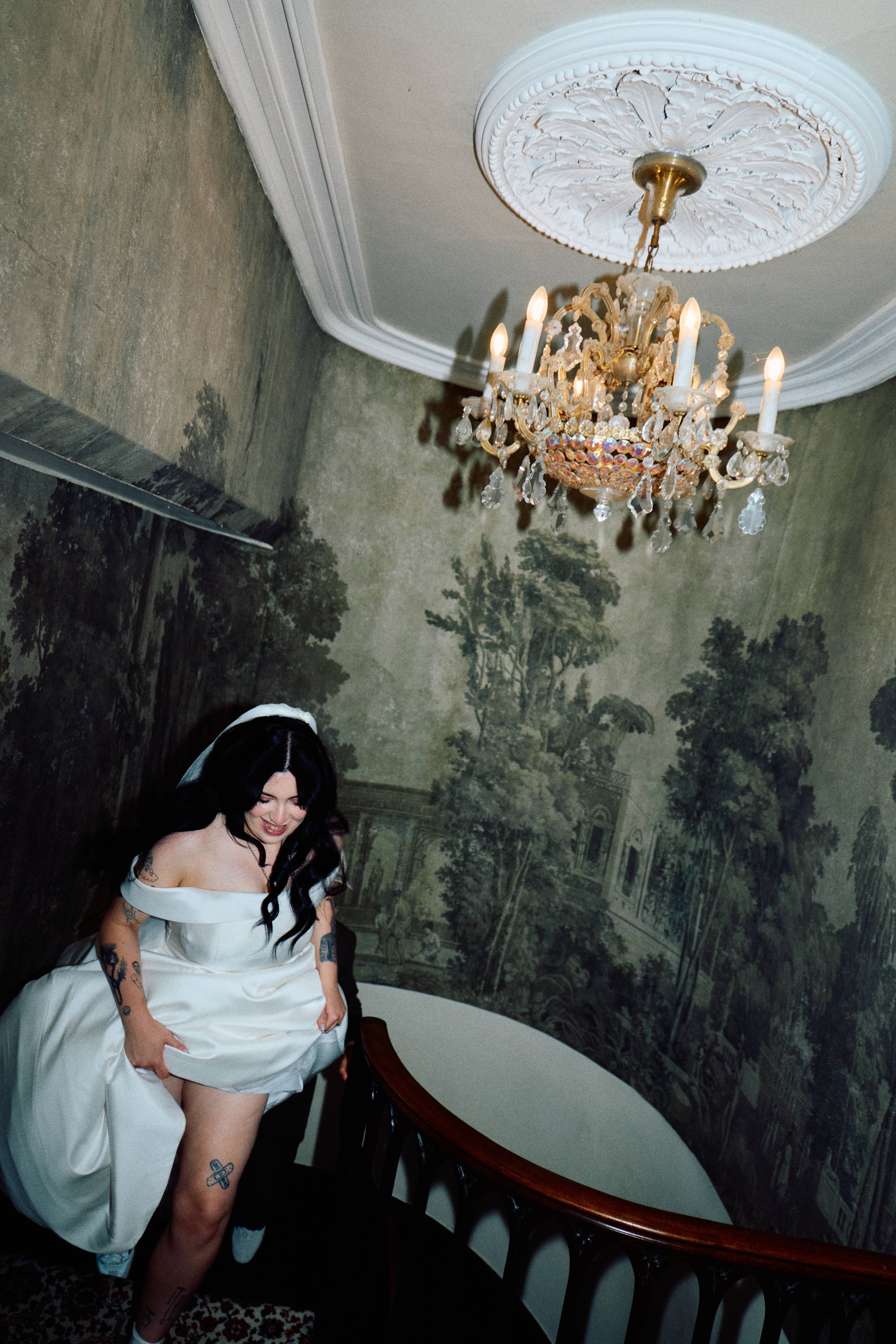 Elizabeth Royse Photography presents a moody cinematic style that blends editorial flair with raw documentary honesty, shown in intimate frames of a bride interacting gently with a horse in soft natural light and descending a grand curved staircase b