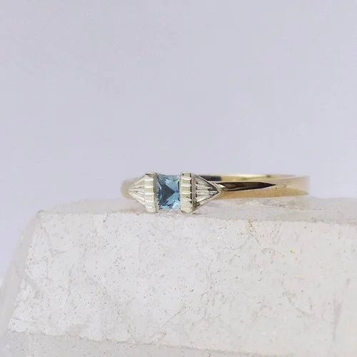 Art deco-inspired gold ring with a blue gemstone by Daniel Darby Jewellery Designer. Handcrafted in the UK, this elegant and modern design is ideal for brides seeking a unique engagement or statement ring.