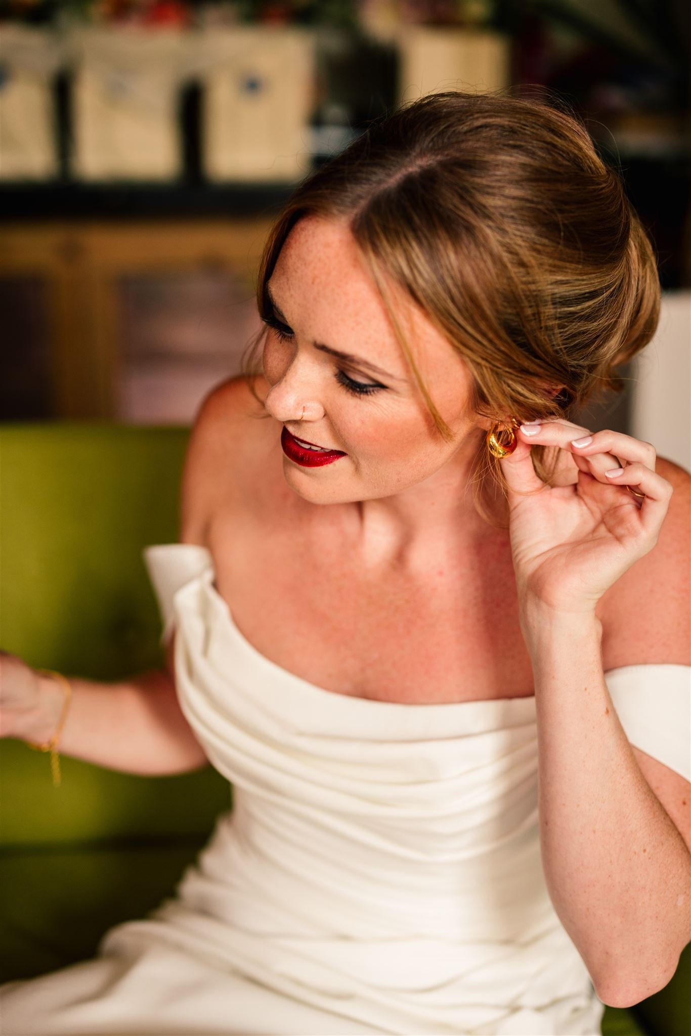 A classic bridal portrait featuring makeup by Powder Blue Artistry, with flawless skin, bold red lips, and softly defined eyes. The timeless look enhances the bride’s elegant off-the-shoulder gown, creating a sophisticated style perfect for romantic 
