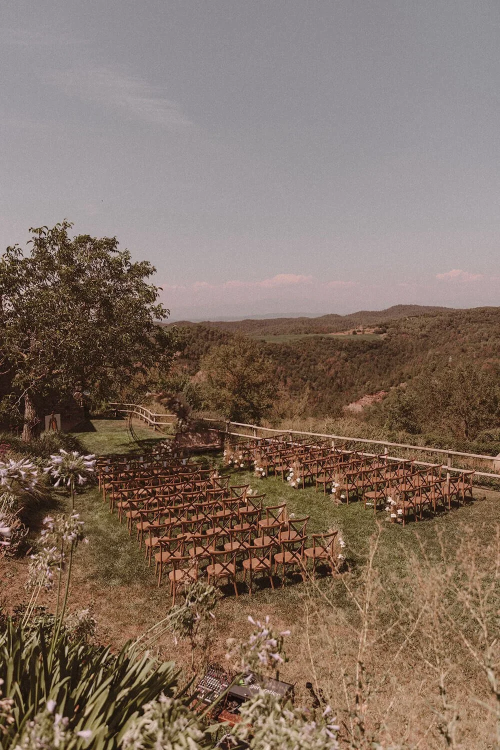 An outdoor wedding ceremony set up in the luscious grounds of, This Must Be The Place, a rustic wedding venue in Barcelona.
