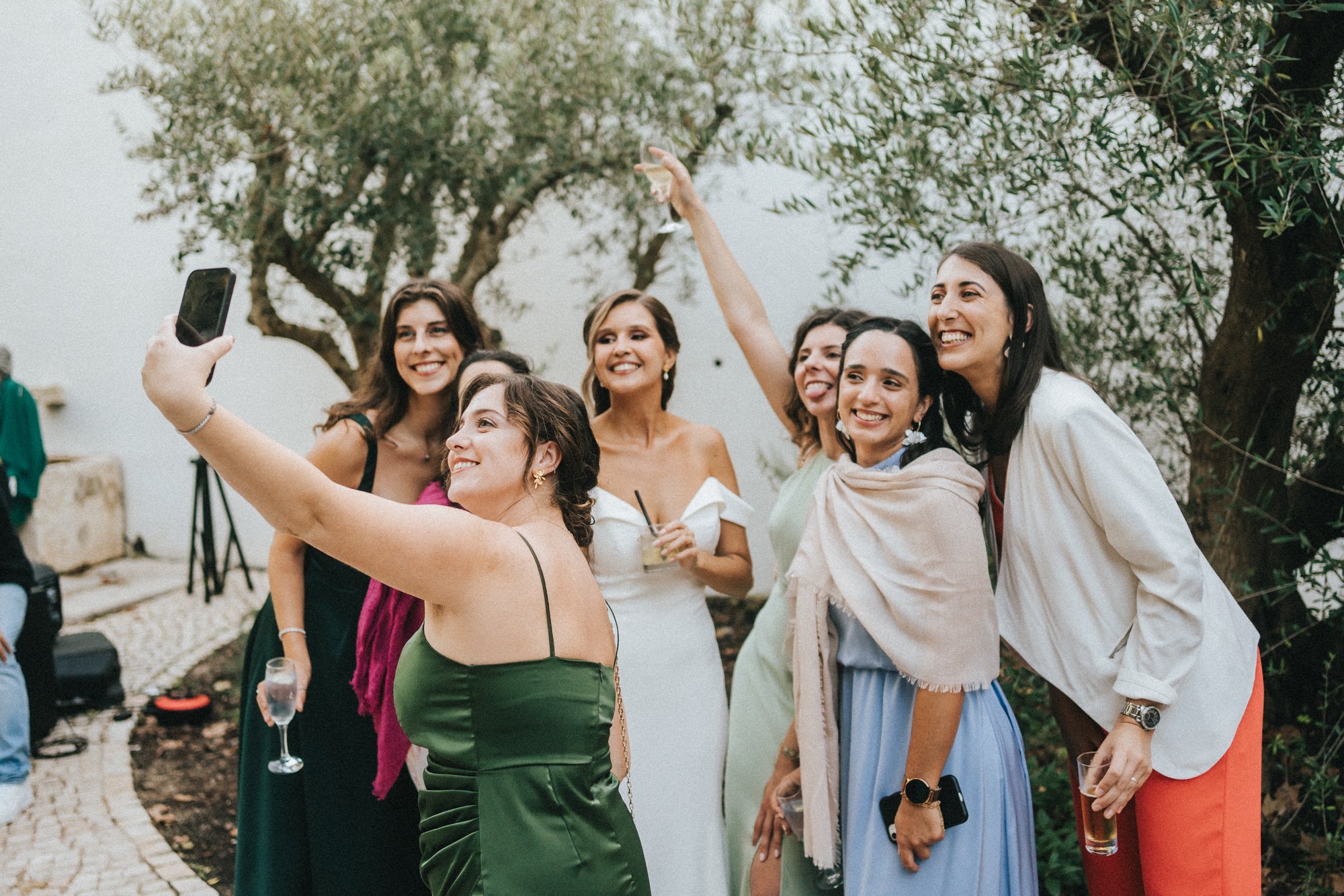 A joyful bride and her guests capture a fun selfie moment during a wedding celebration, laughing and raising their glasses. This lively scene reflects the authentic, candid memories preserved with VOXU audio guestbooks — where guests leave heartfelt 