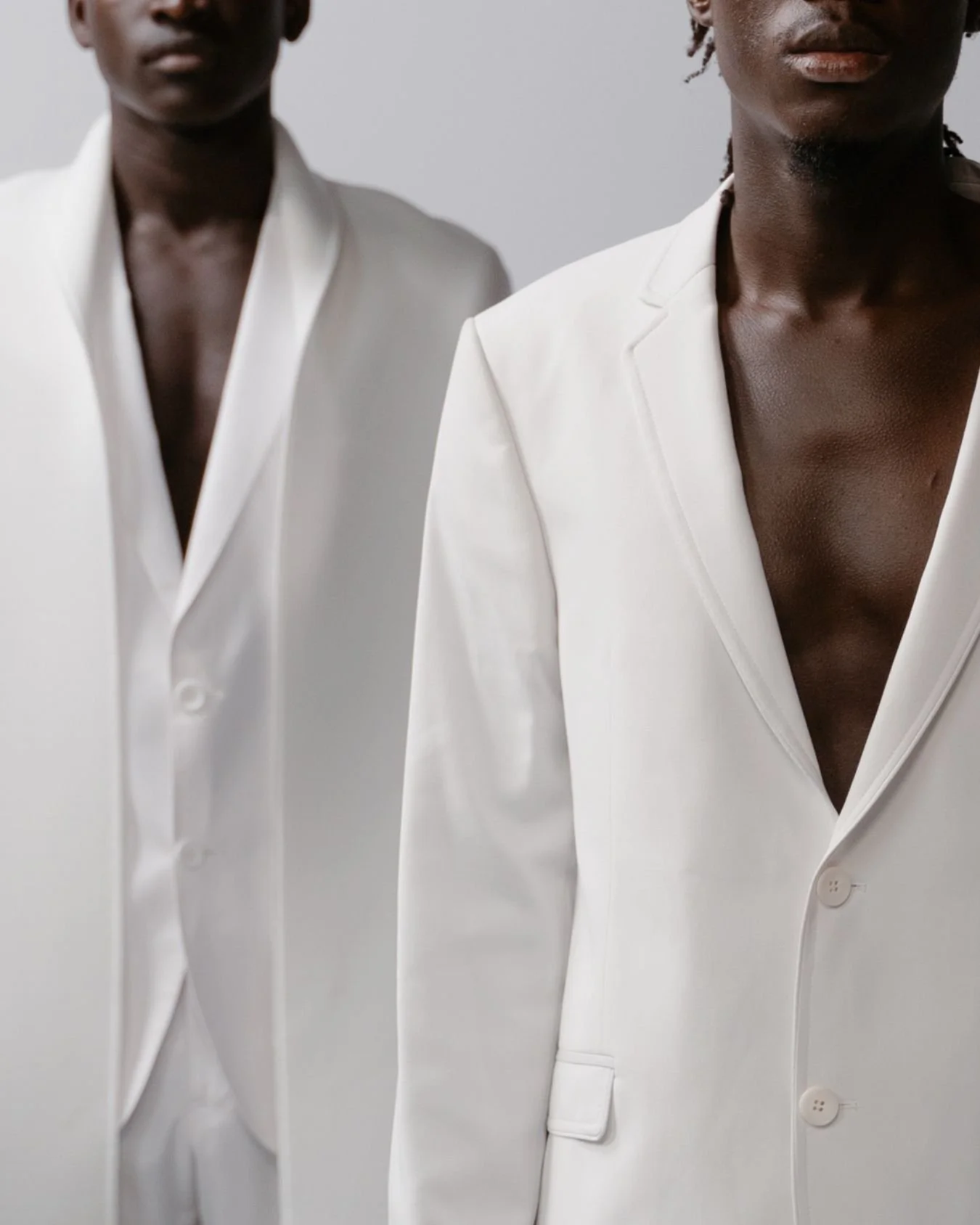 2 Black grooms wearing white suits.