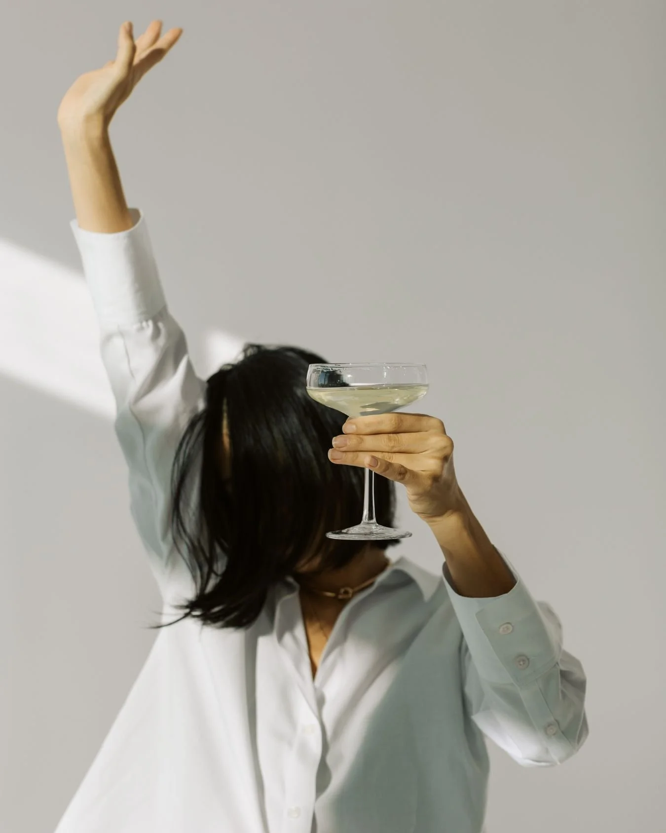 A bride drinking a cocktail at her hen do celebration.