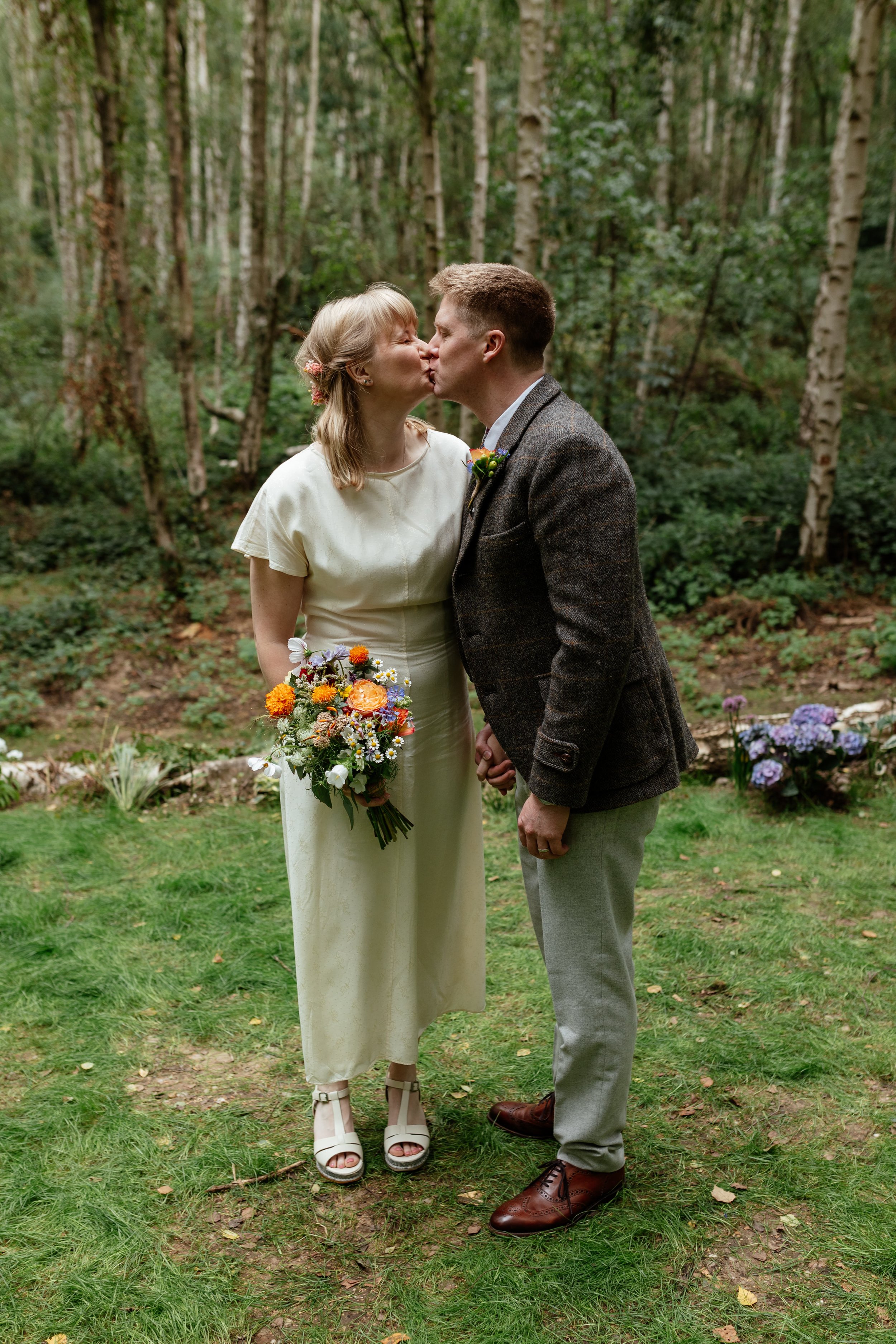 A bride and groom kissing in Sherwood Forest.