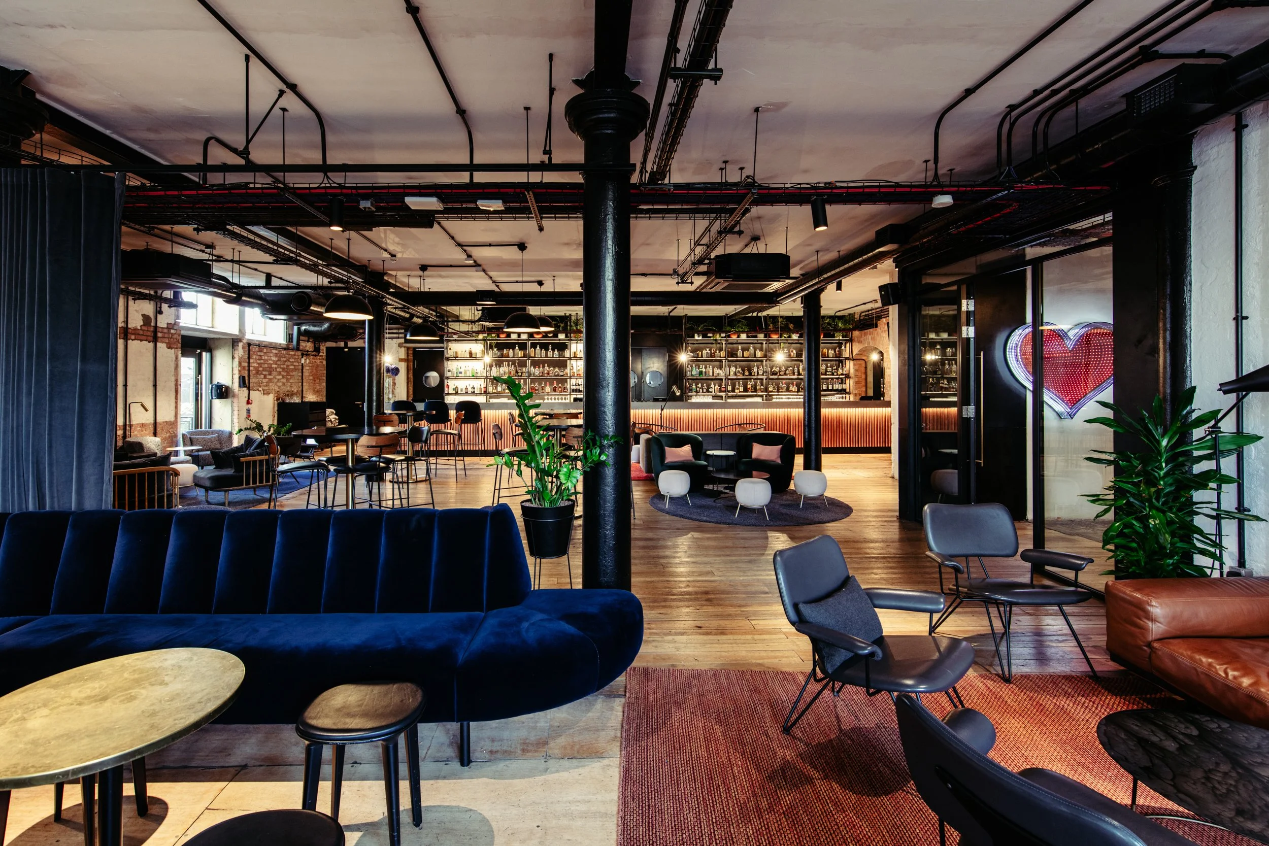 A stylish industrial wedding bar at Ministry Venues, showcasing exposed brick, polished wooden floors, statement lighting and contemporary lounge seating, ideal for modern London weddings, drinks receptions and evening celebrations.