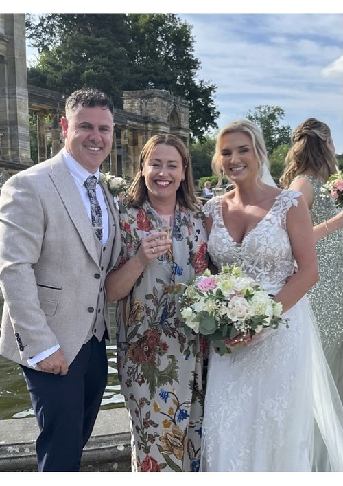 Wedding celebrant Vicky standing with a newly married couple at an outdoor ceremony, showcasing her role in creating meaningful and joyful celebrations.