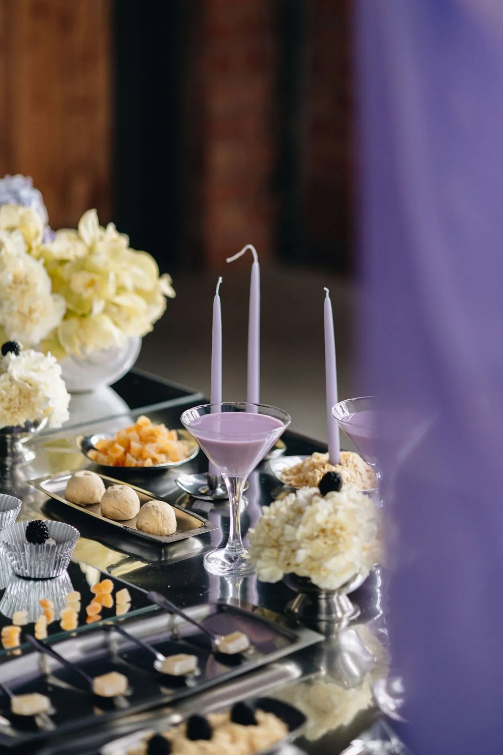 Orange Tree Weddings styling and décor featuring an elegant dessert table with lilac cocktails, soft florals and refined table details, perfect for a modern, design-led wedding celebration.