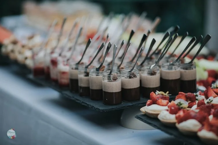 Elegant dessert display by Regis Banqueting, featuring rich chocolate mousse pots with mini spoons and delicate strawberry tarts. This beautifully presented wedding dessert station highlights the caterer’s attention to detail and expertise in creatin