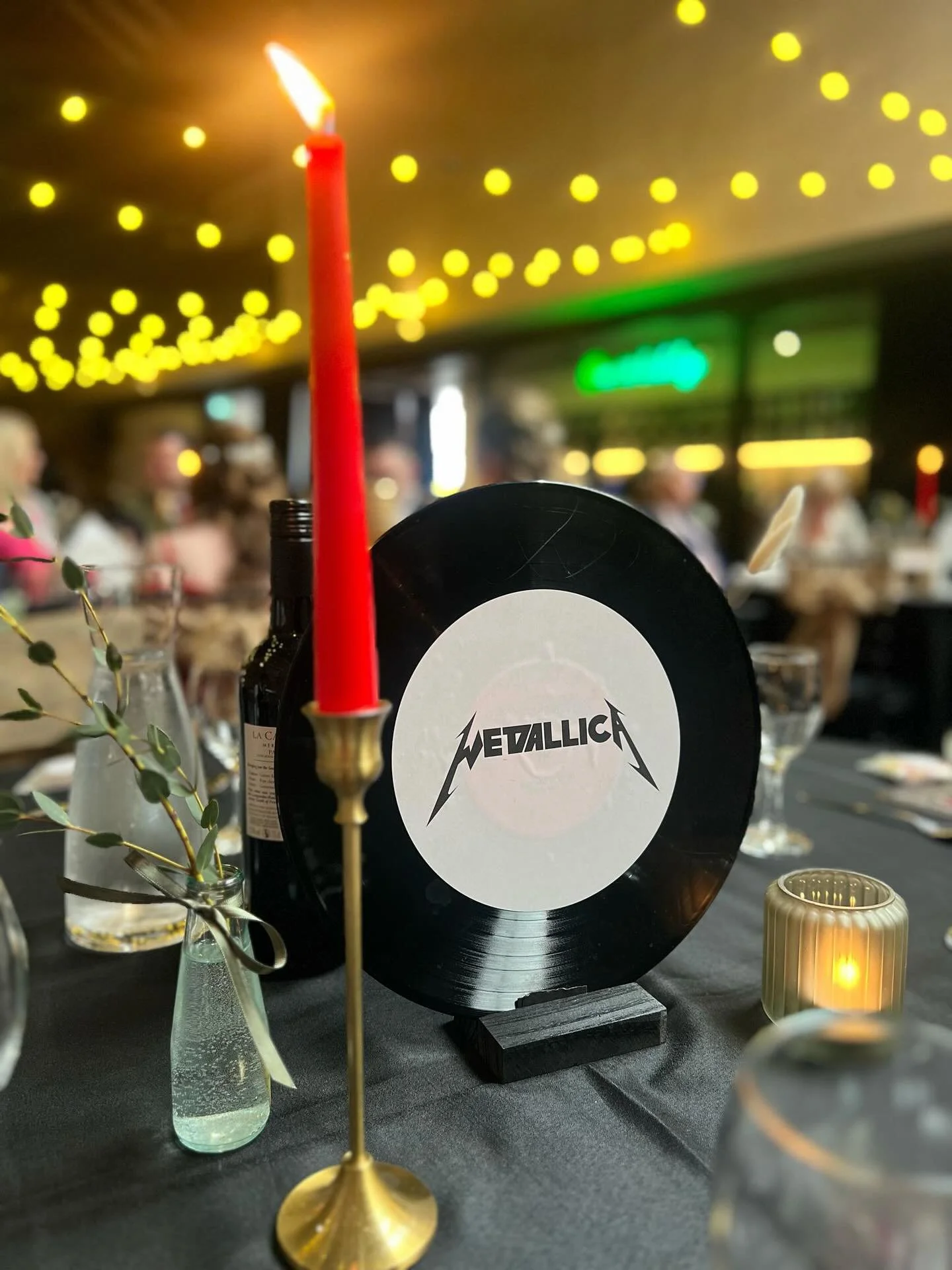 Rock-inspired wedding table décor by Toasty Type, showcasing custom hand-painted vinyl record signage styled with bold typography and music iconography. Designed and created in Glasgow, this alternative wedding stationery pairs personalised illustrat
