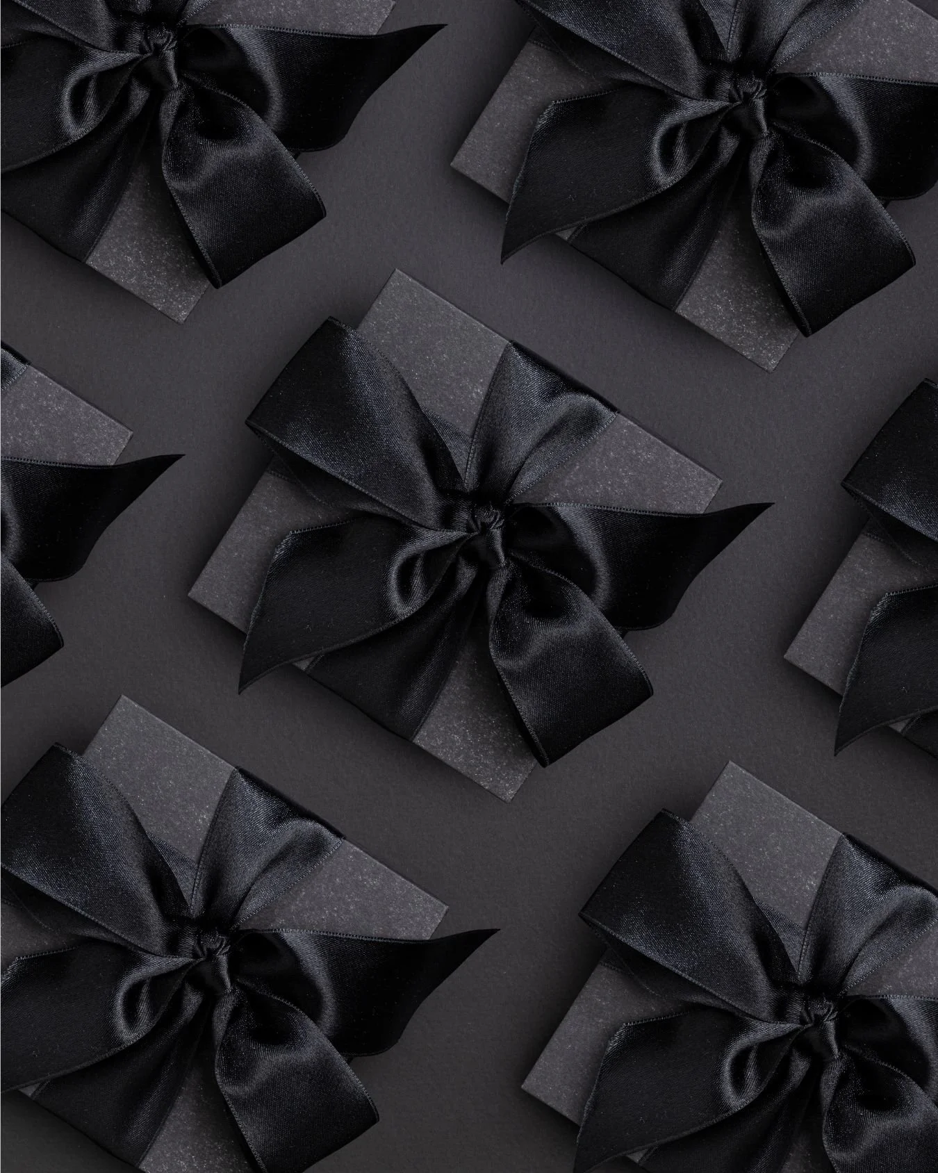 A series of luxurious gift boxes with black ribbon.