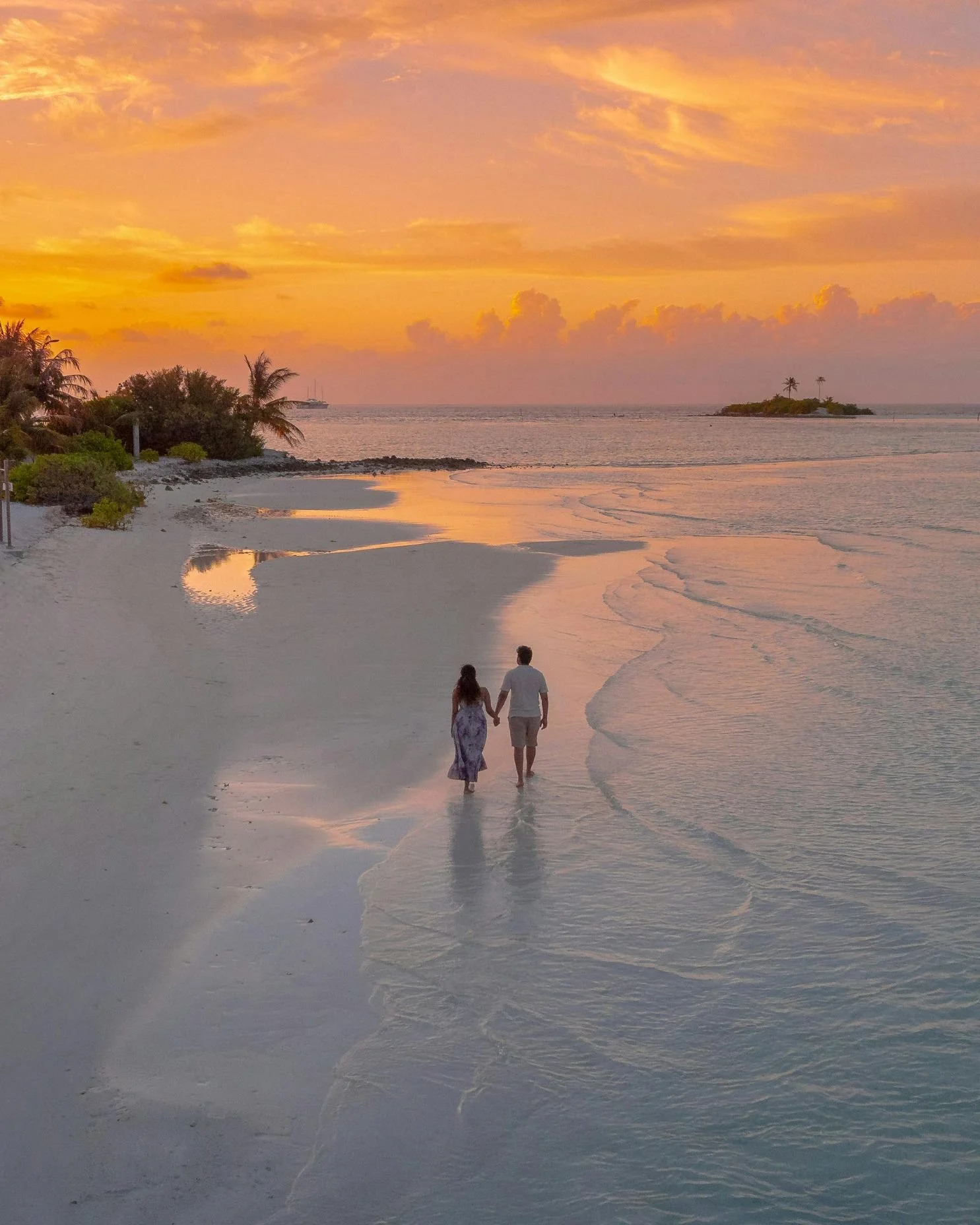 A couple taking a romantic walk on their honeymoon on a tropical island.