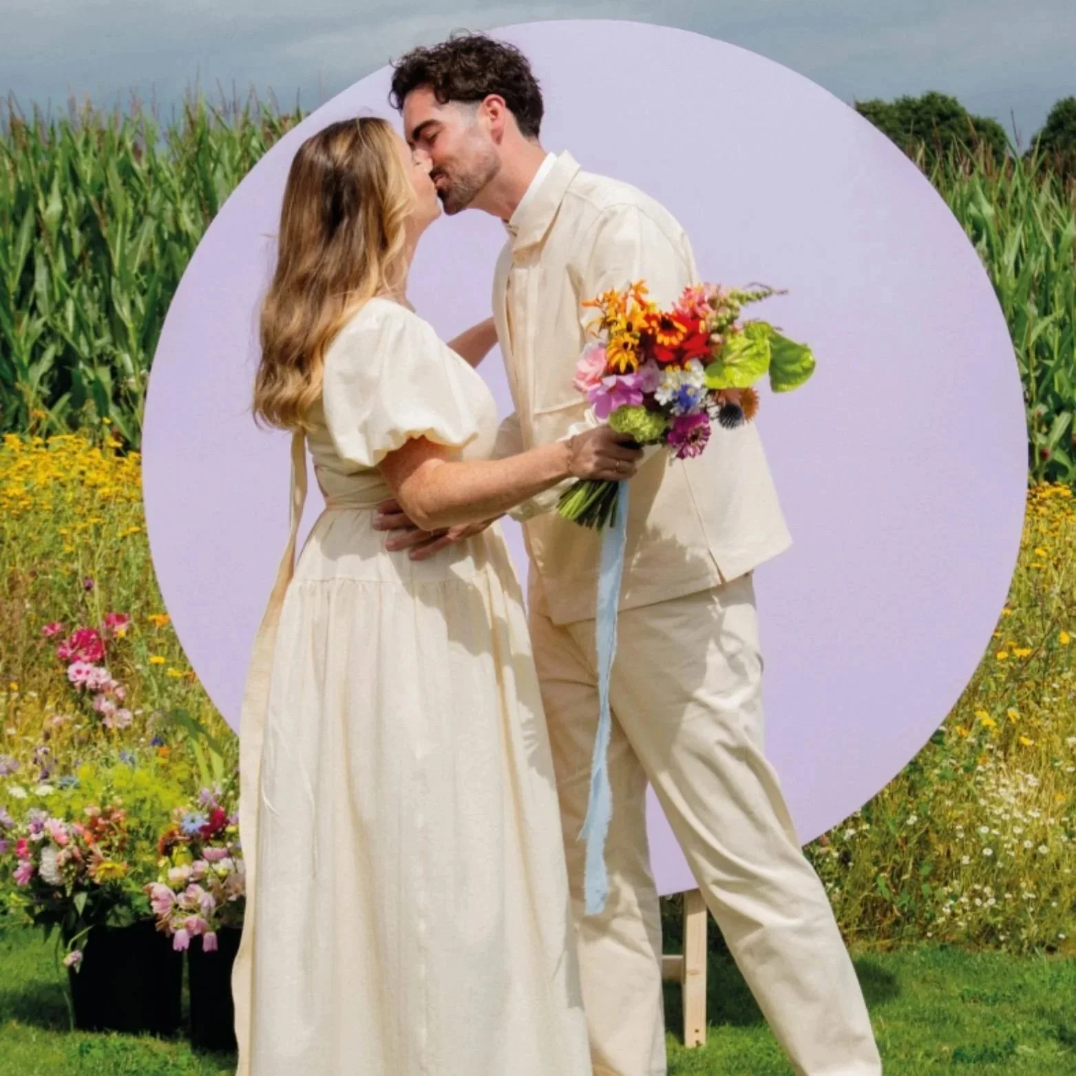 A modern bride and groom kissing in a flower field. The photo is from a real wedding feature in MNT Magazine.