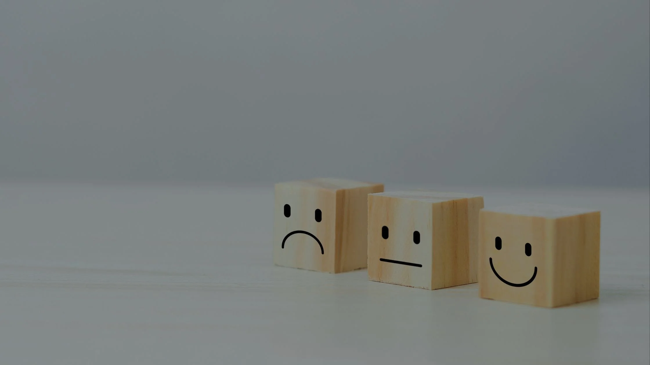 3 wooden block representing wedding  leads. One has a happy face, one is neutral and one is sad.