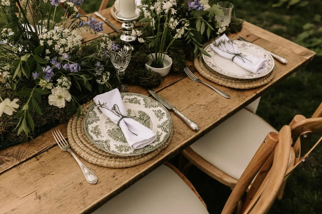 Two beautiful place settings complete with florals and napkins, styled by Wild Soul Weddings, eco wedding planners in the UK. Sarah Grace Photography. Dominic Williams Photography