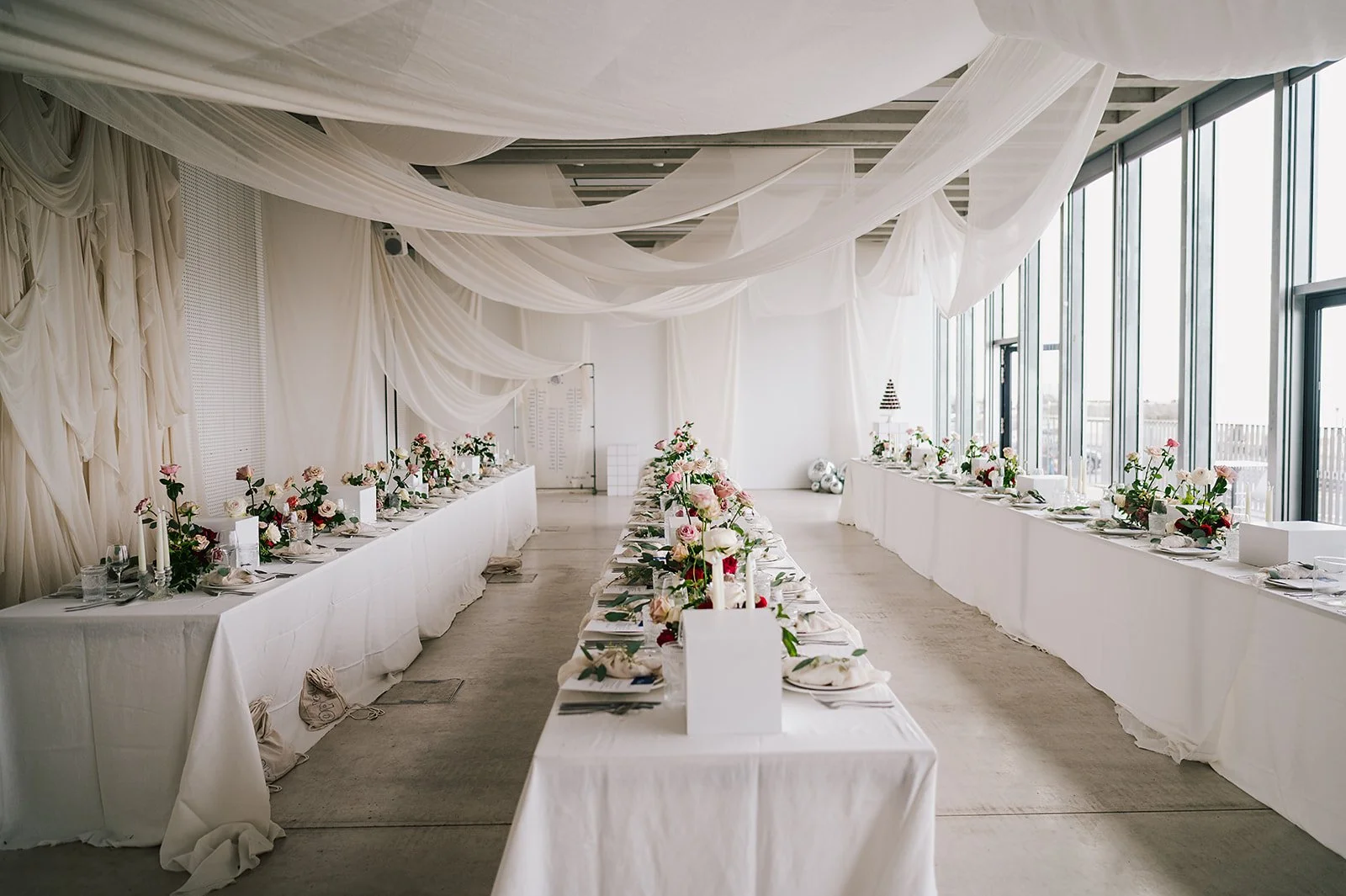A photo of a stylish, modern wedding day set up with white drapes.