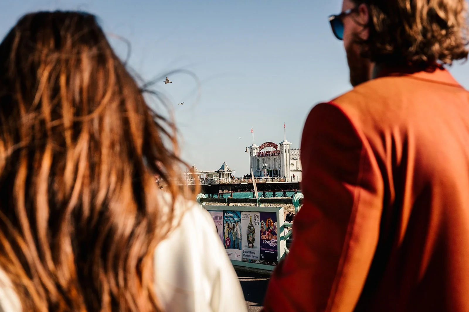 Couple look out towards Brighton Pier near Pier Court Wedding Venue, capturing a relaxed, romantic seaside wedding moment by the coast.