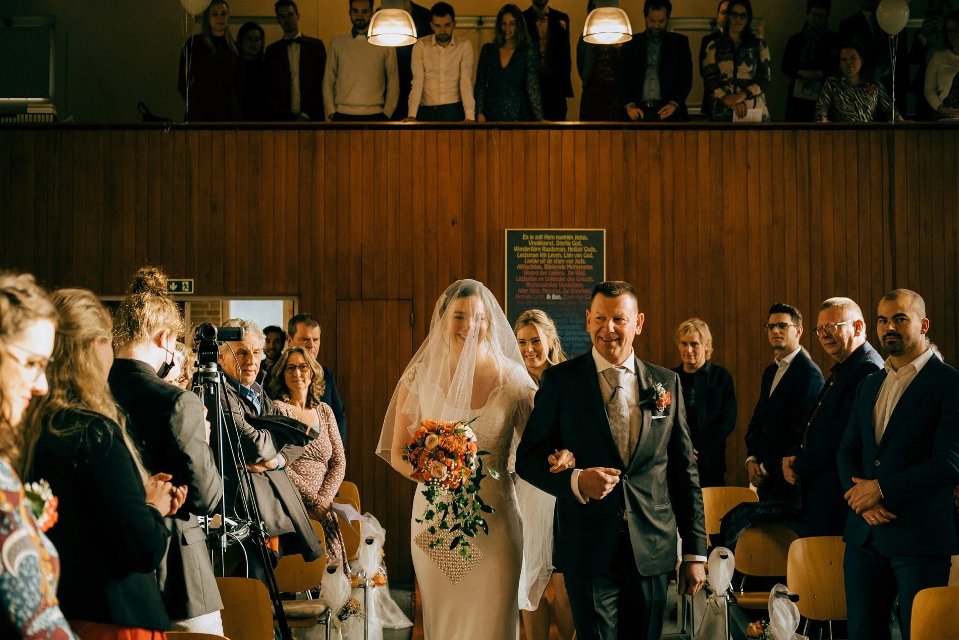 A bride walks down the aisle with her father as guests look on, capturing a joyful, emotional ceremony moment by Quiet Mornings Wedding Photography in Scotland.