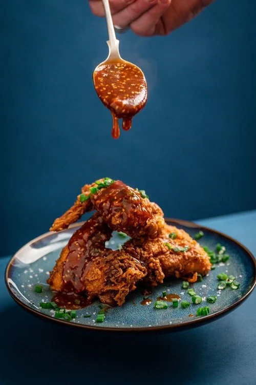 Crispy fried chicken drizzled with rich, sticky sesame and soy glaze by Hardy’s Catering. This vibrant dish showcases the caterer’s modern flair and bold flavours, perfect for weddings, private dining, and luxury events. Garnished with fresh chives, 