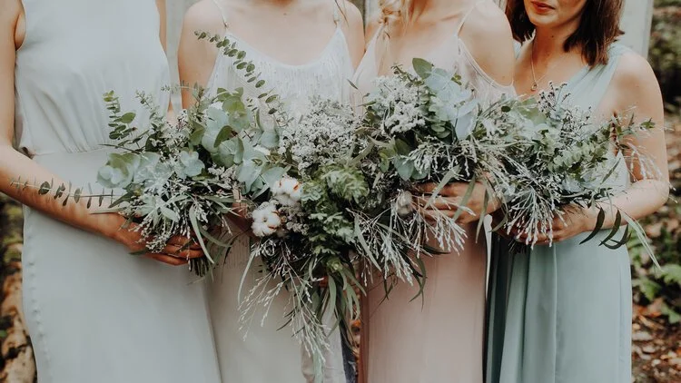 Elegant bridesmaid bouquets by Catherine Short Florals featuring soft greenery, eucalyptus, delicate white blooms and natural textural foliage. Paired with pastel dresses in a woodland setting, these fresh modern arrangements highlight Catherine Shor