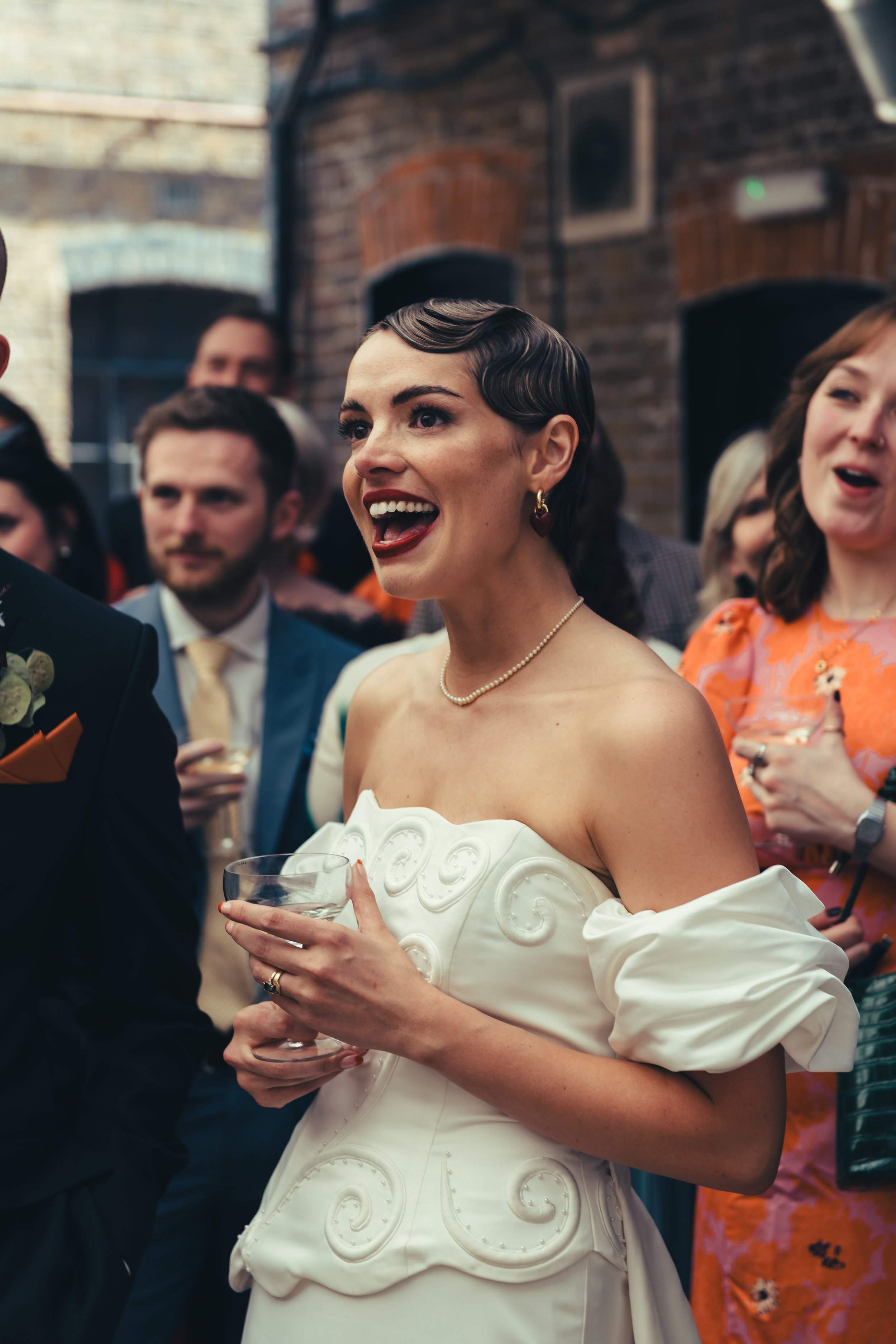 A radiant bride with a vintage-inspired makeup look by Powder Blue Artistry, featuring flawless skin, bold red lips, and softly defined eyes. The elegant beauty styling complements her statement gown, creating a timeless and sophisticated look for mo