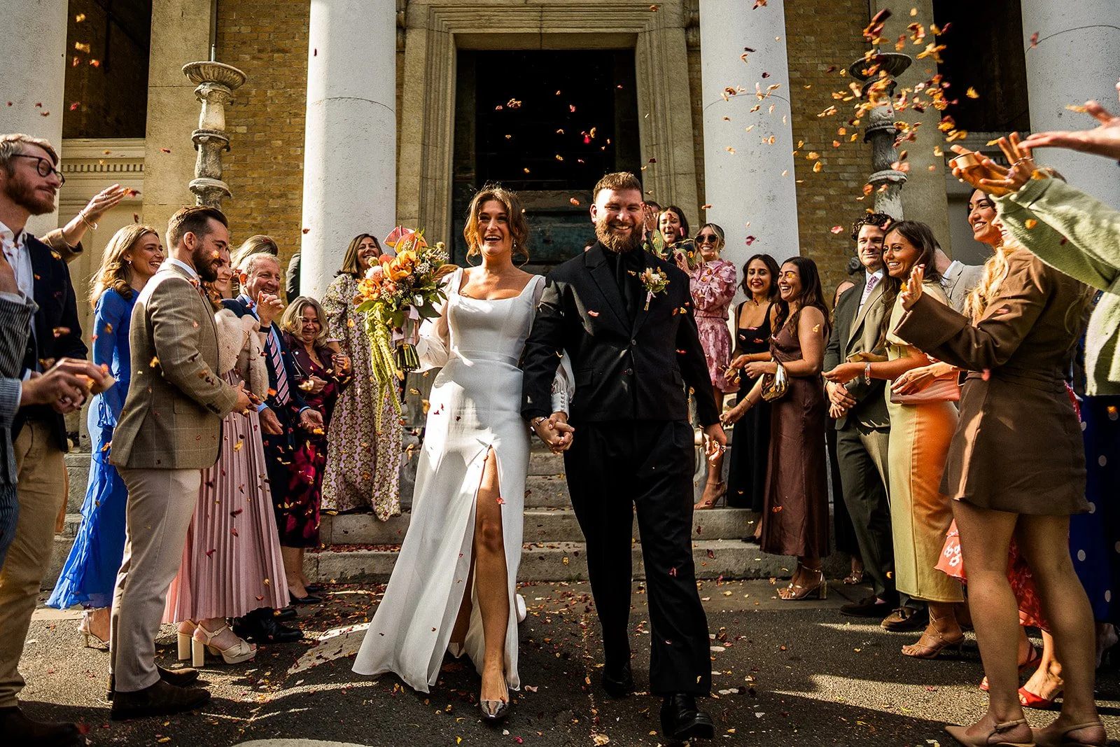 A bride and groom being showered in confetti as they leave the Asylum Chapel after their wedding ceremony.