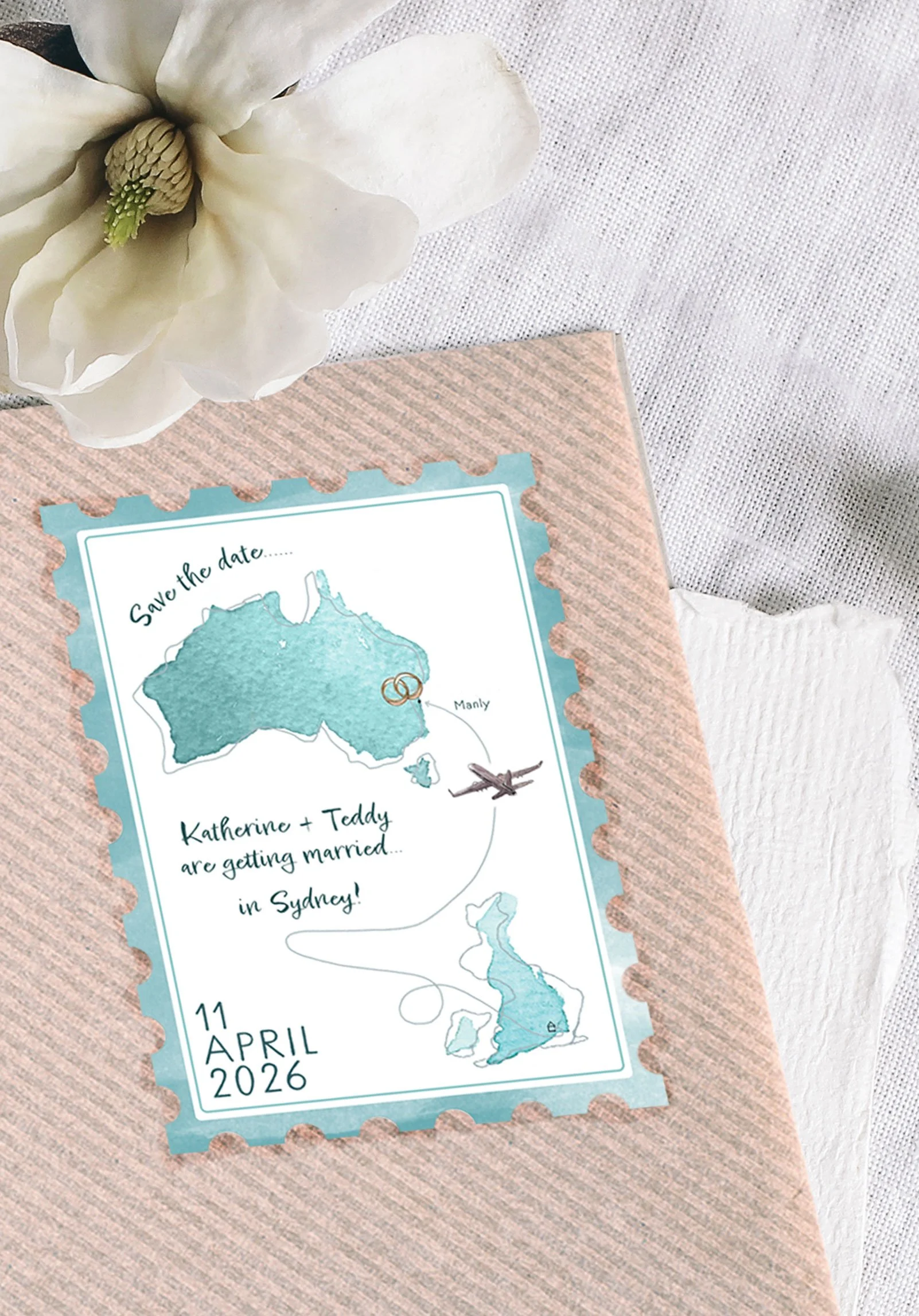 A playful destination wedding save the date by Feather & Ink Stationery featuring a stamp shaped card with hand painted maps of Australia and the UK linked by a flight path illustration and engraved rings marking Sydney styled on textured linen with 