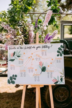 Travel-inspired wedding seating plan illustrated by Bee Davies Illustration. Featuring a world map design with hand-painted florals and elegant calligraphy, this bespoke sign adds a personal, artistic touch - perfect for couples celebrating their lov