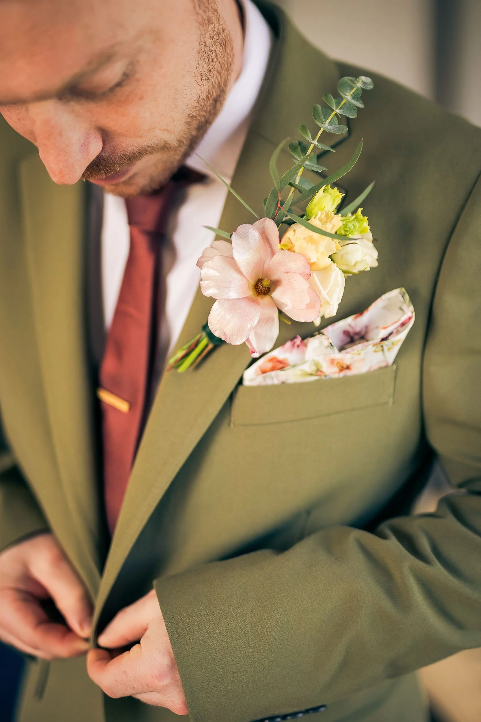 A groom doing his buttons up for a styled shoot