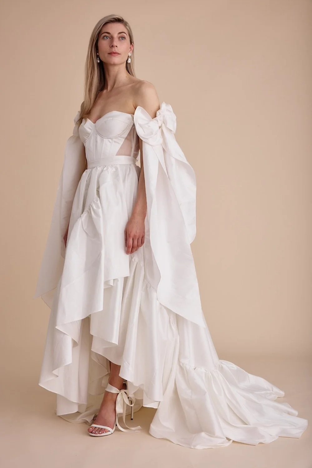 An upcycled wedding dress with a big, bow sleeve details by Swans Bridal, West Sussex.