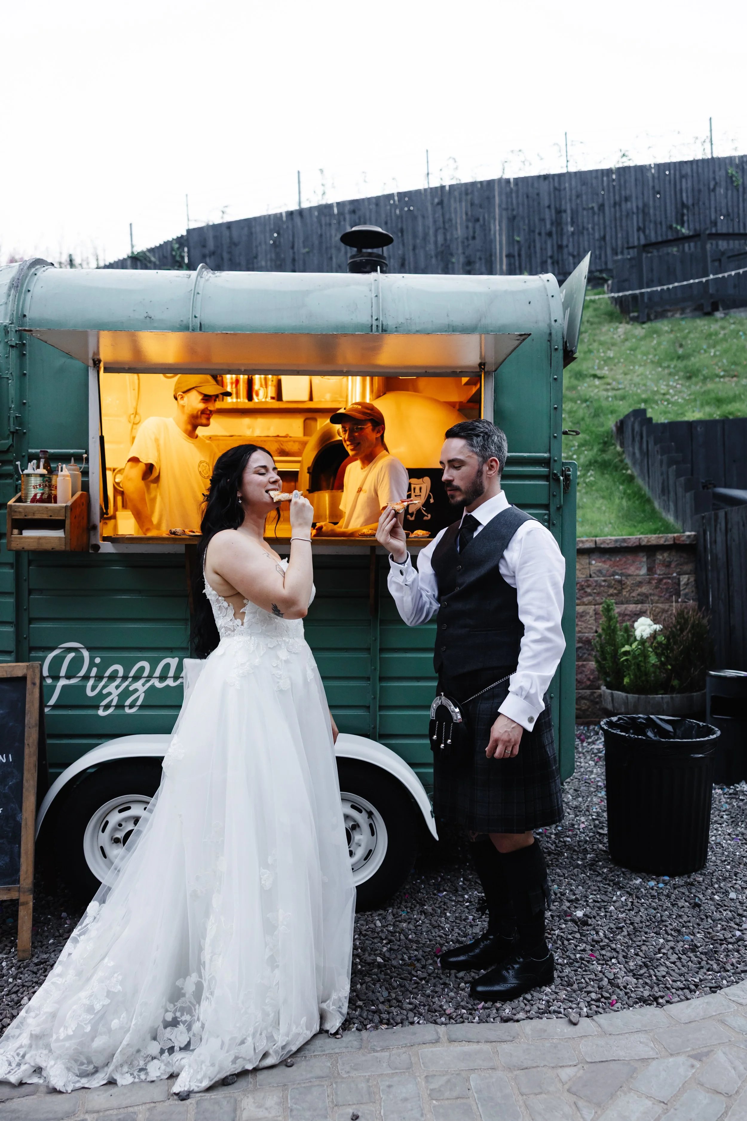 Marie and Oliver eating a slice of Pizza from the Dough Man's Land Pizza Truck.