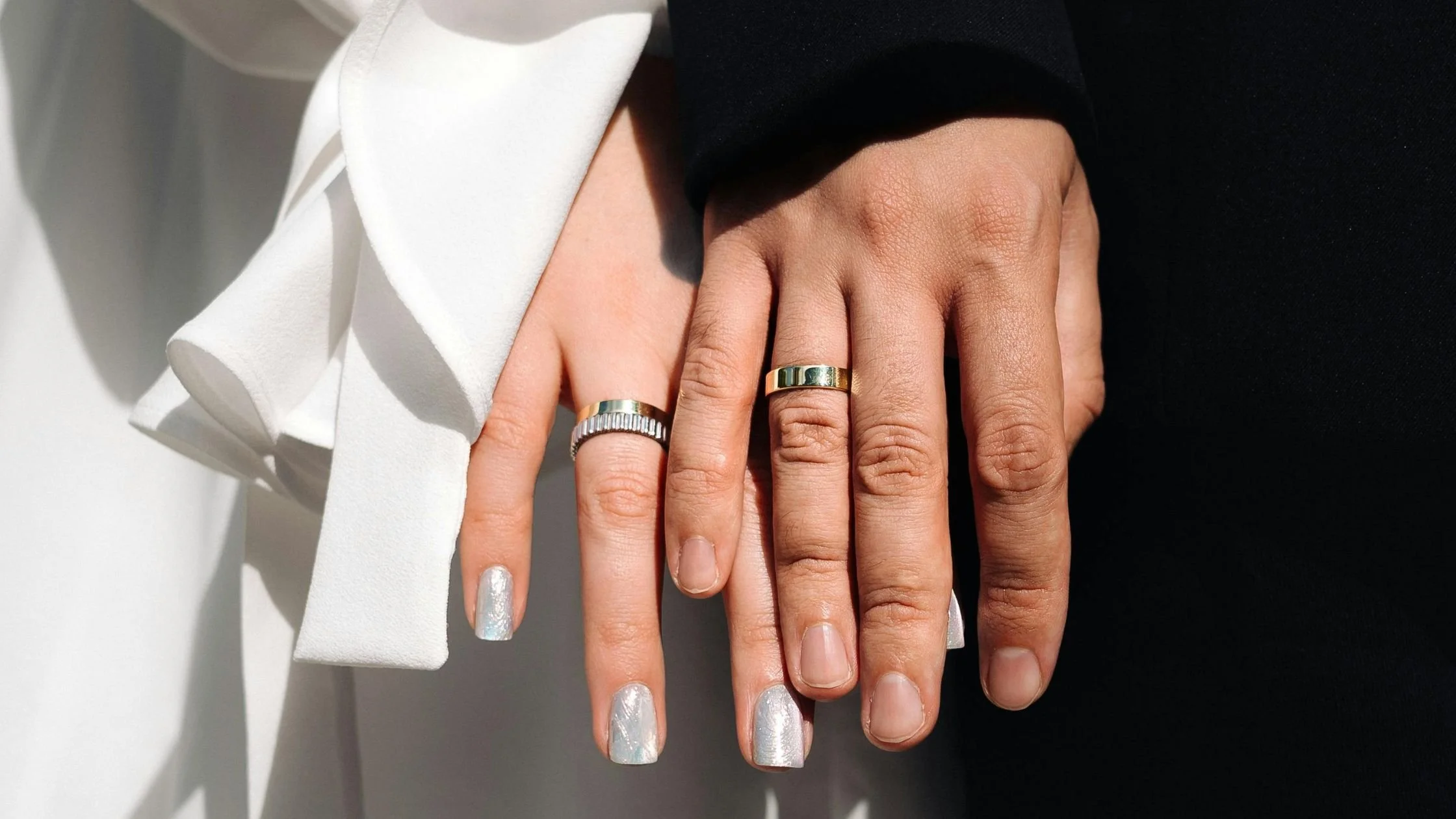 A modern bride and groom showing off their unique wedding rings.