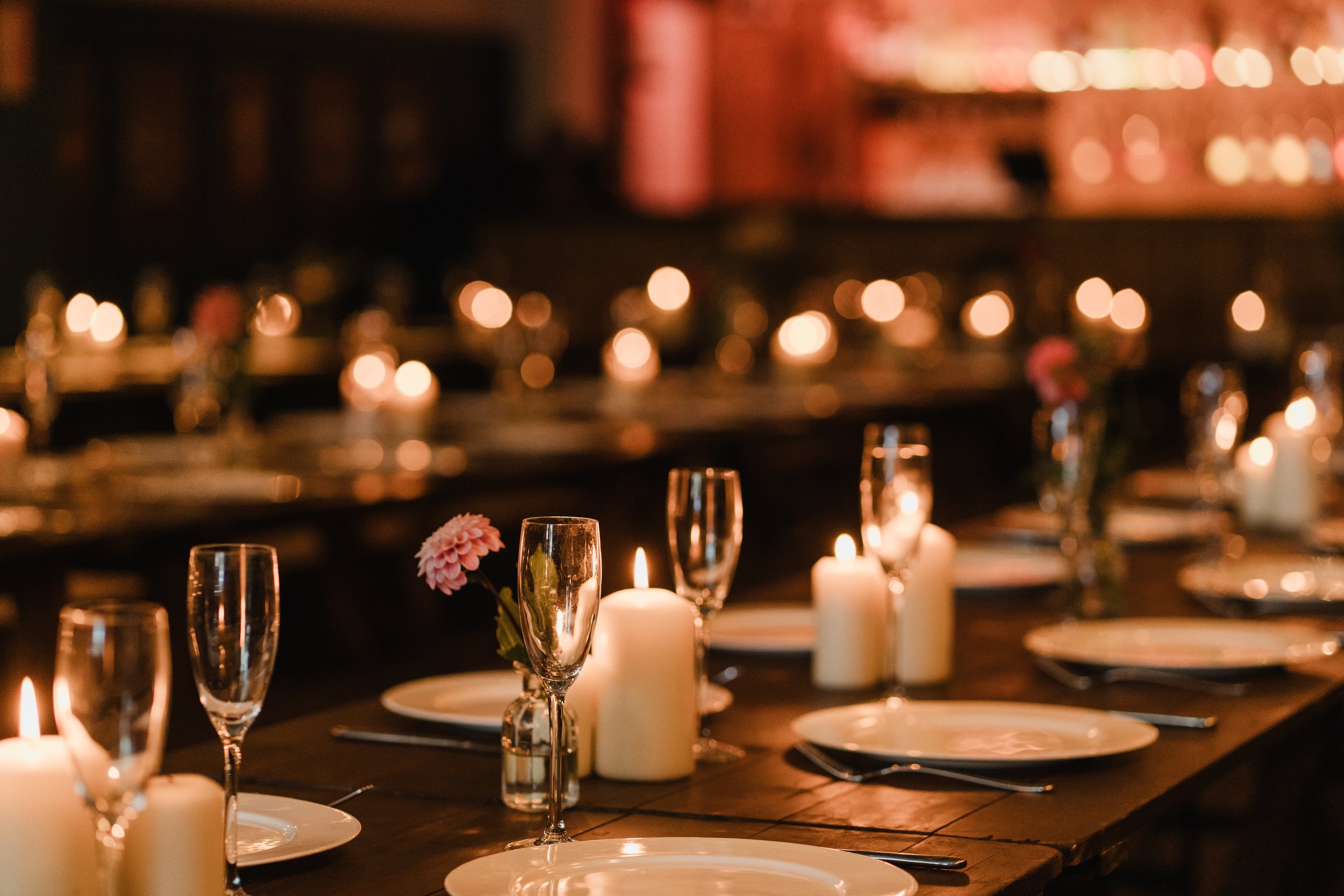 Intimate candlelit table settings at Colours Wedding Venue in Shoreditch, capturing a warm, atmospheric London wedding reception with modern styling.