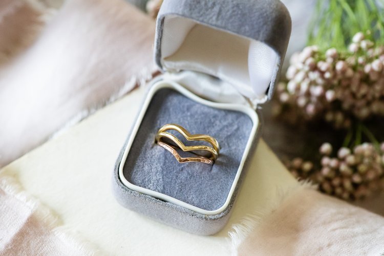 Elegant curved gold and rose gold stacking rings by Nikki Stark Jewellery, displayed in a soft grey velvet ring box. Handcrafted in the UK, these bespoke designs make beautiful wedding or engagement rings for modern brides.