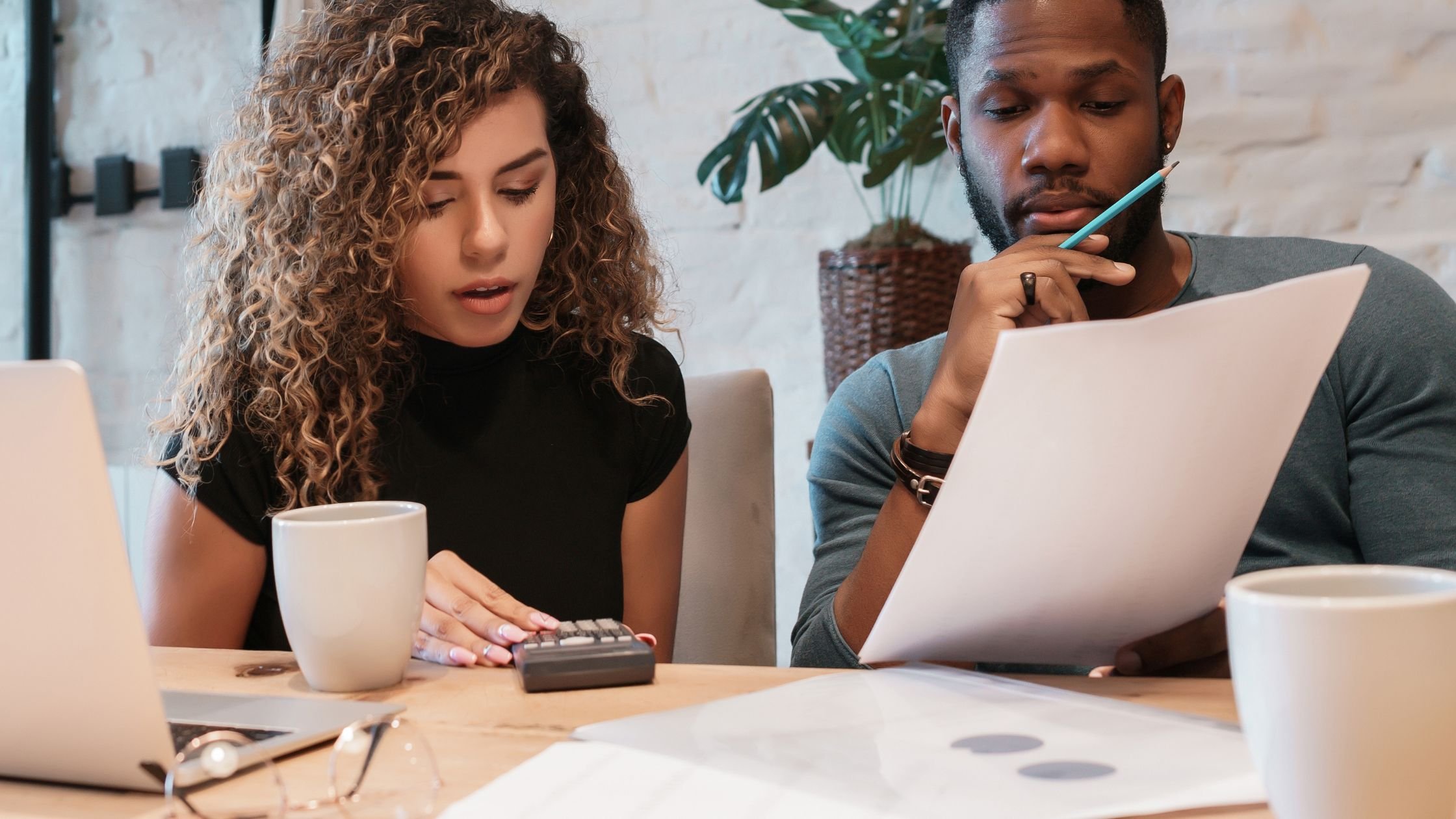 A modern couple are planning their wedding and working out budgets with spreadsheets.