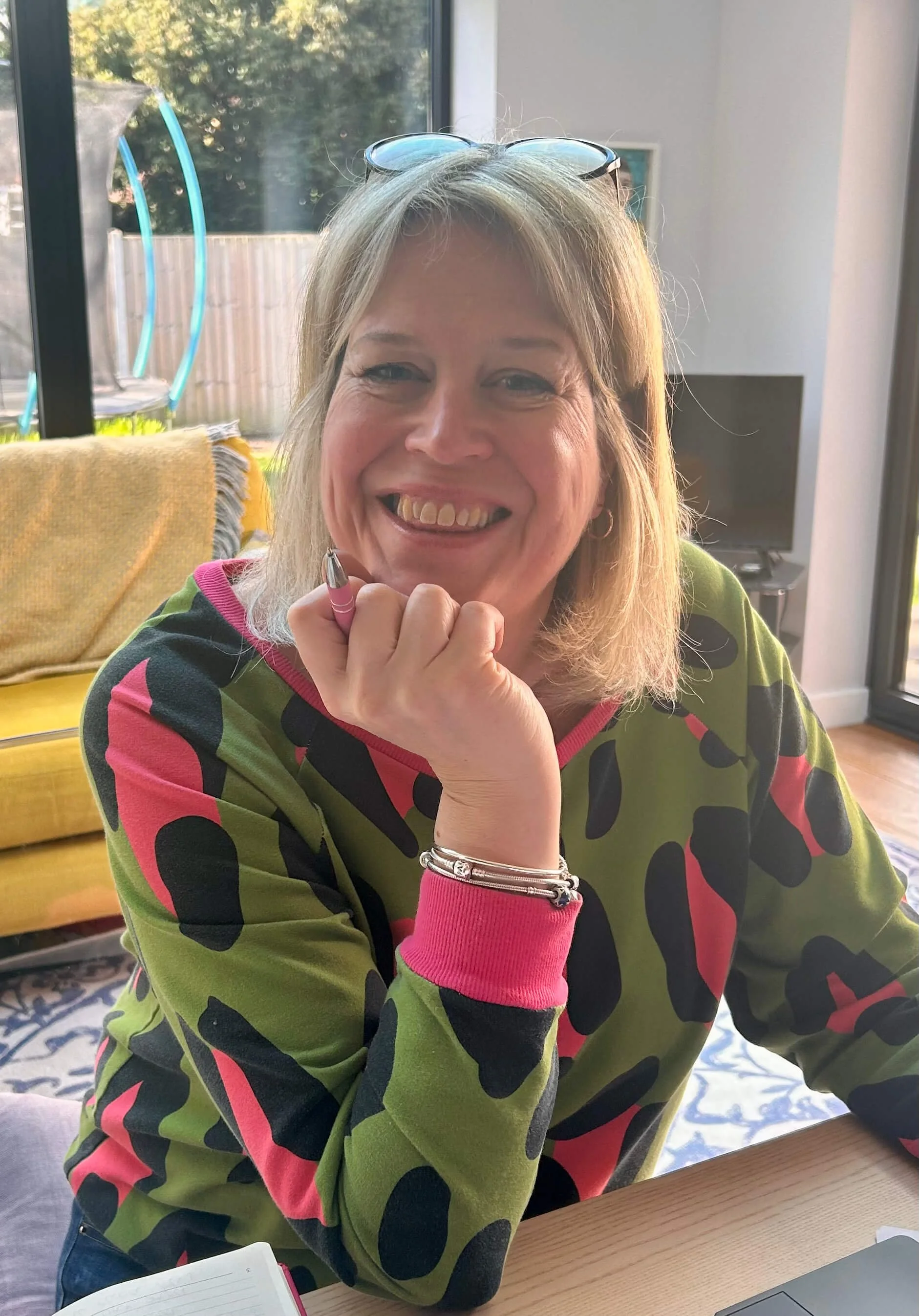 Becky M Celebrant in a pink, black and green top, smiling at the camera.
