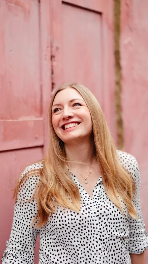 Portrait of Rachel, the artist behind Blue Pumpkin Calligraphy, captured against a soft pink backdrop. Specialising in modern calligraphy and bespoke wedding stationery, her warm, creative style shines through - perfect for couples seeking elegant, h