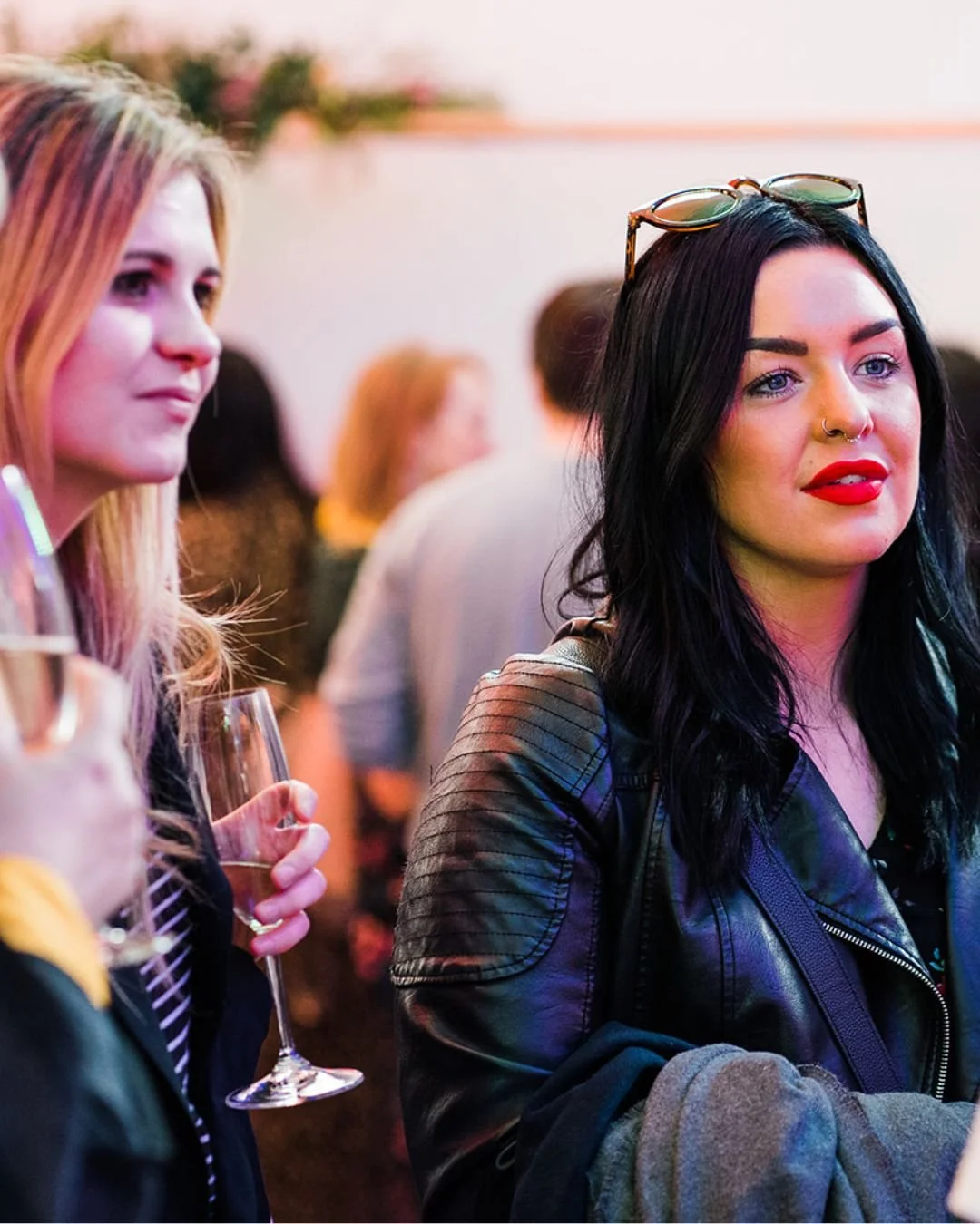 2 modern brides are listening intently as a wedding professional talks at a wedding planning event in London.