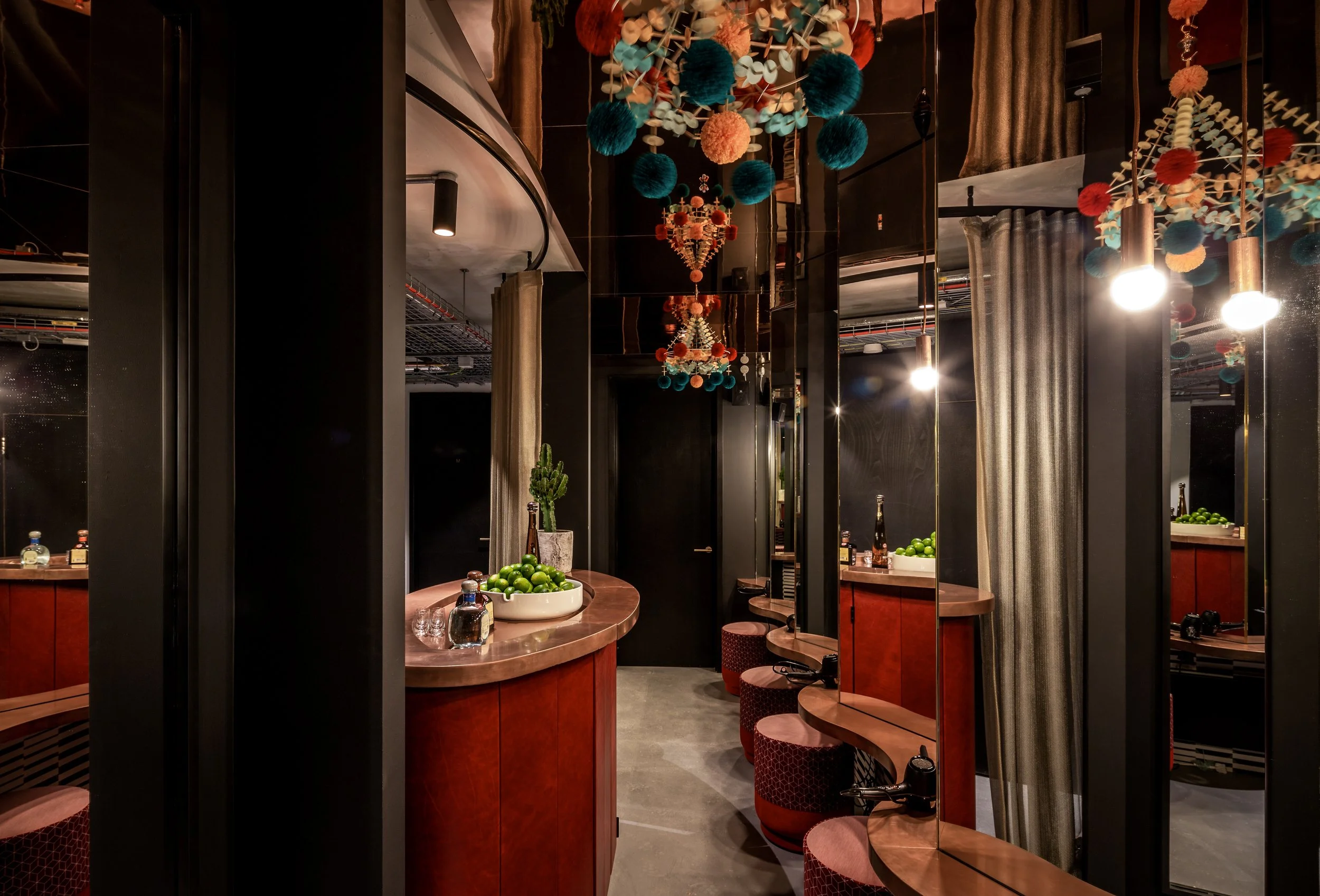 A stylish and design-led bathroom interior at Ministry Venues, showcasing mirrored walls, warm wood finishes, statement lighting and playful hanging décor, reflecting the venue’s contemporary, creative aesthetic and attention to detail - perfect for 
