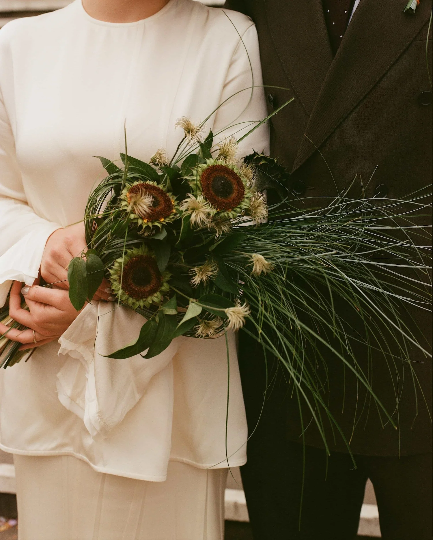 A close up of a modern bride holding a unique bridal bouquet by Kitty Willow Flower Studio. Photo by Emily Krouse.