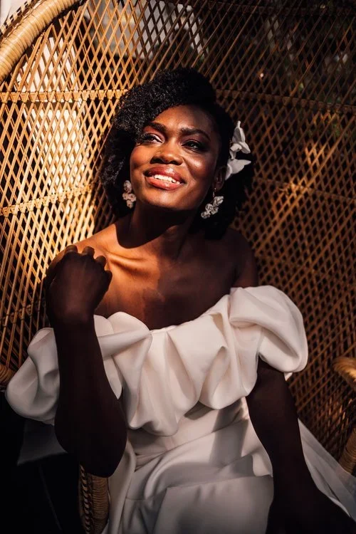 A beautiful Black bride with vegan friendly makeup is looking up towards the sun.