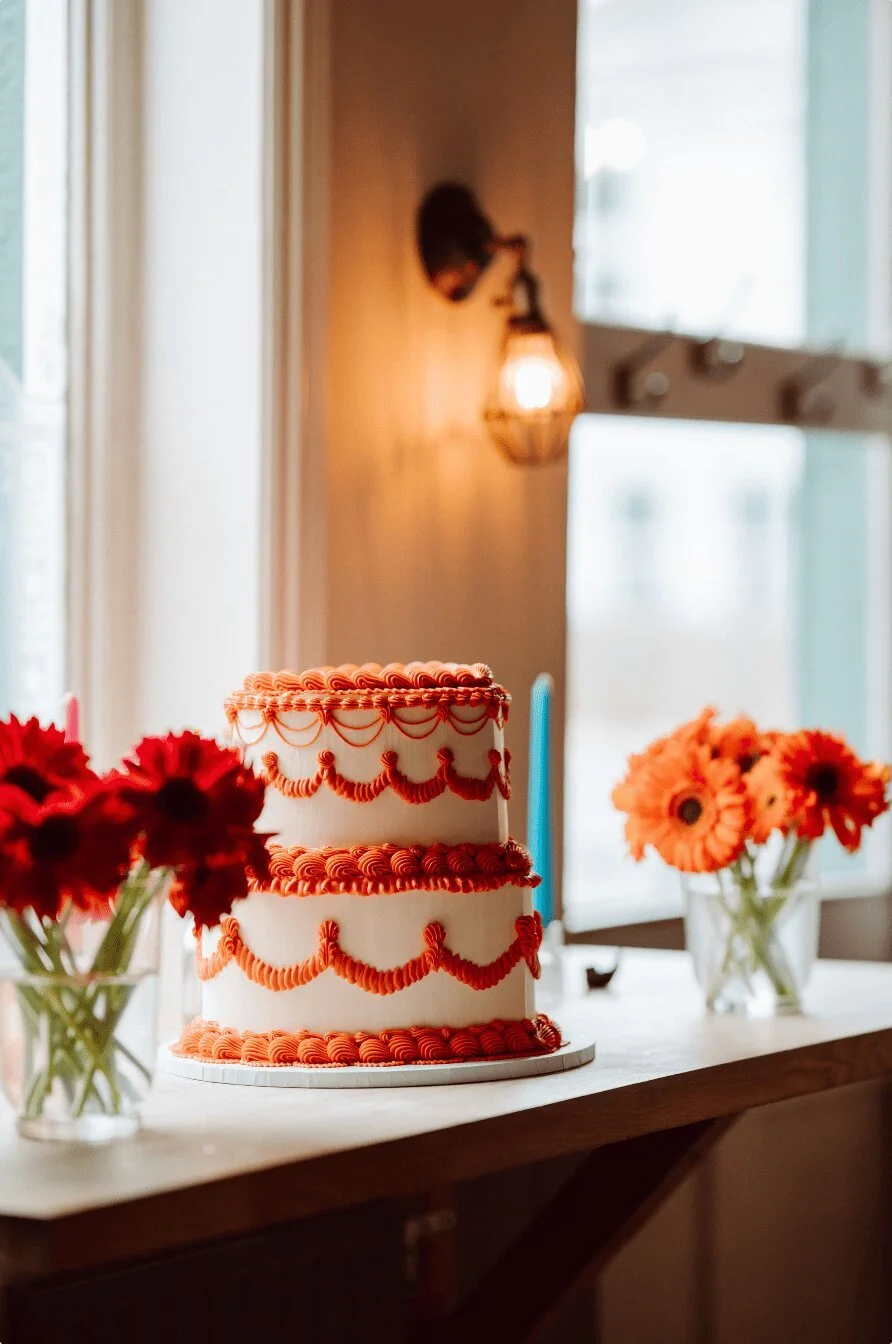 Retro-inspired wedding cake by The Cake Hun featuring tiered vintage piping, ivory buttercream and bold red detailing. A modern, design-led wedding cake blending nostalgic styling with contemporary aesthetics, perfect for creative, stylish weddings a