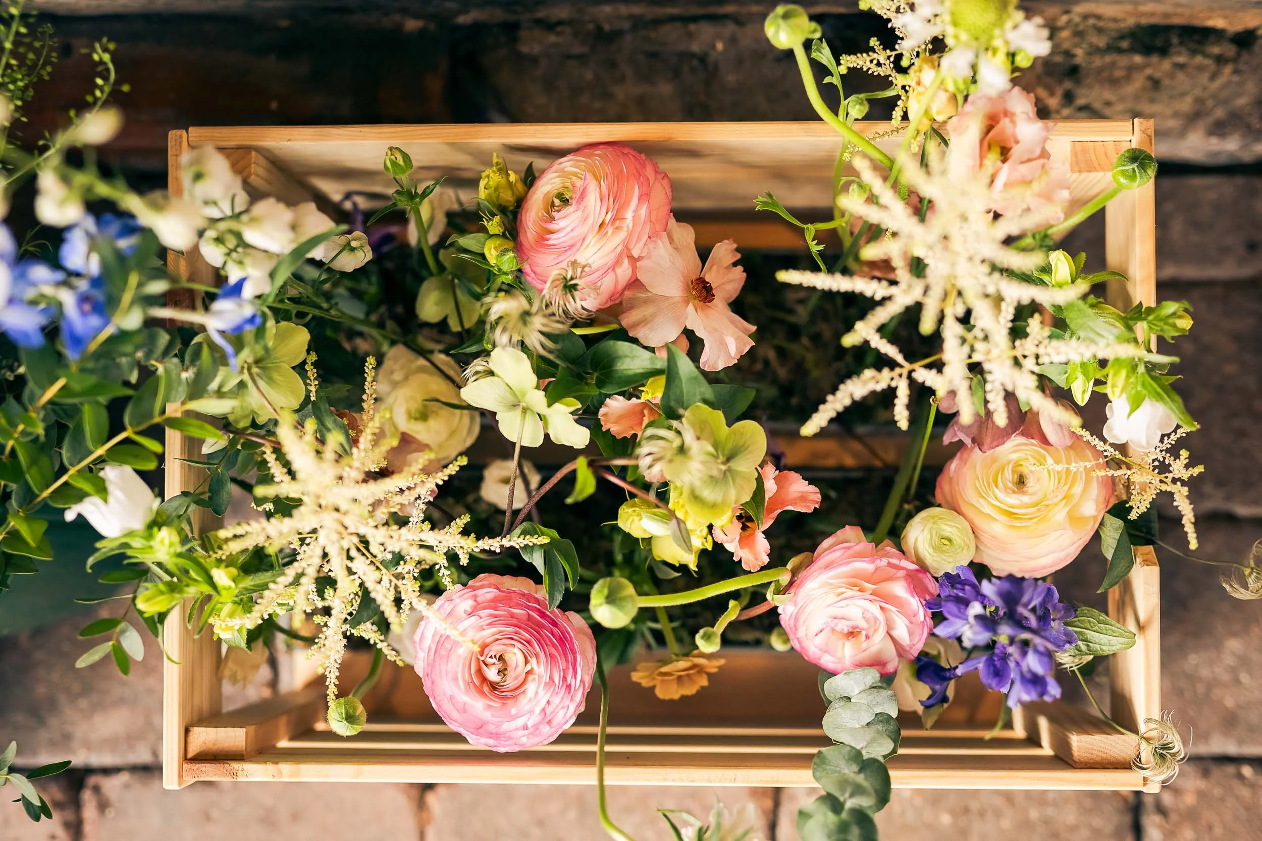 A wooden crate of summery wedding flowers at Elmley Nature Reserve.